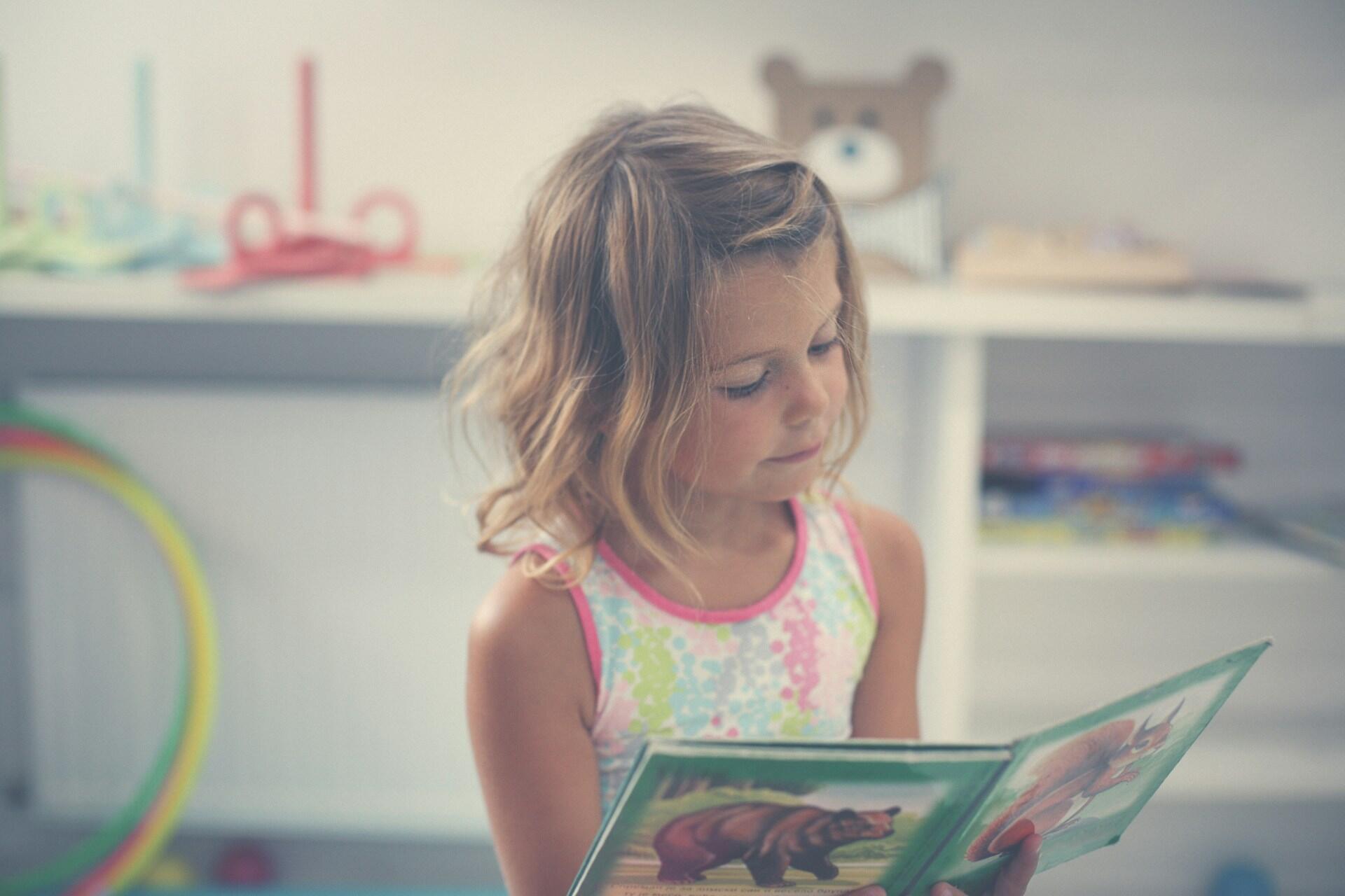 Bambina sfoglia un libro: come individuare i sintomi della dislessia nei bambini
