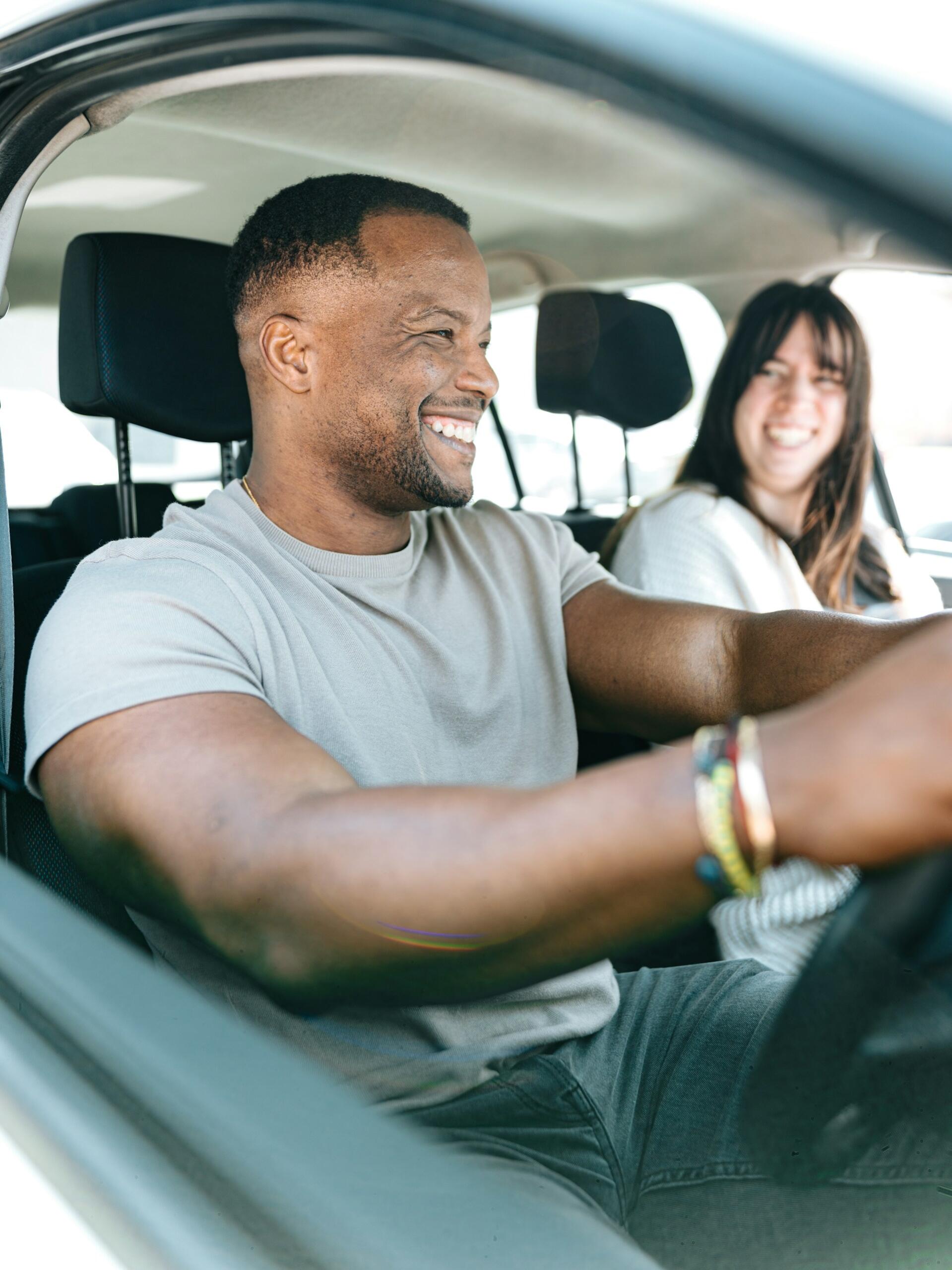 Uomo impara a guidare insieme alla sua istruttrice di guida. 