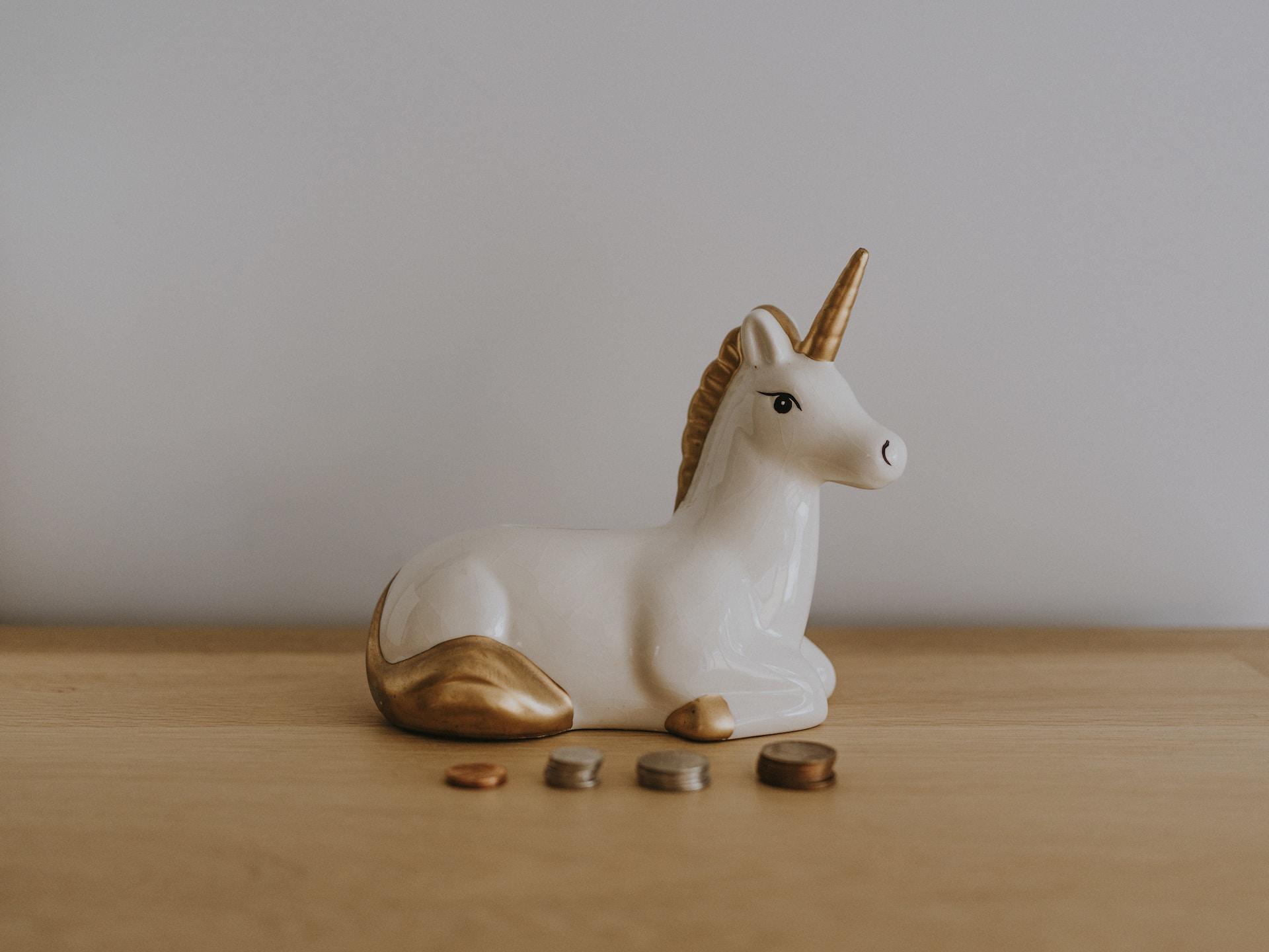 Salvadanaio a forma di unicorno e monetine