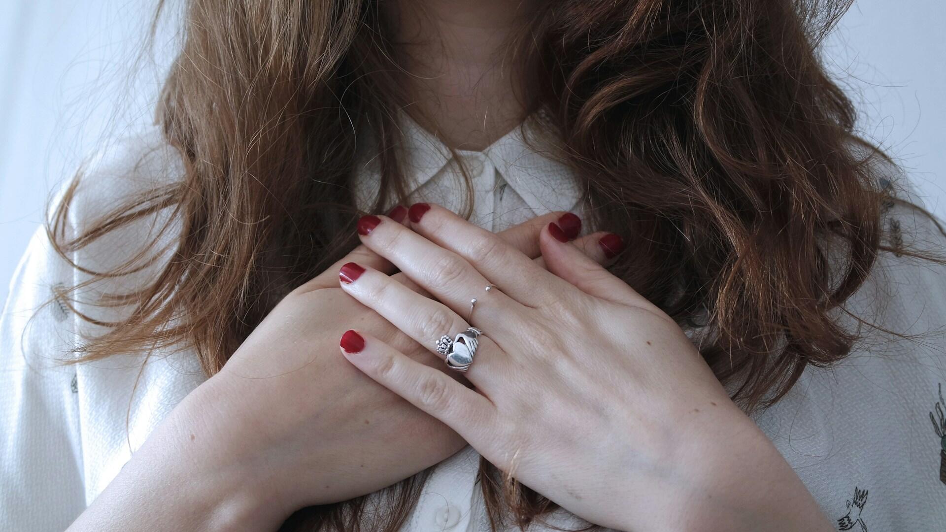 Donna con le mani congiunte sopra il petto.
