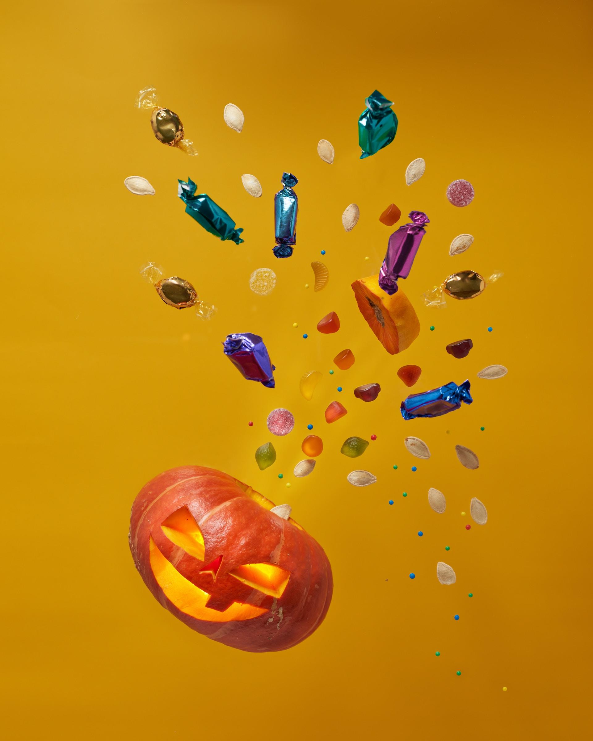 Zucca di Halloween da cui fuoriescono caramelle e dolcetti.