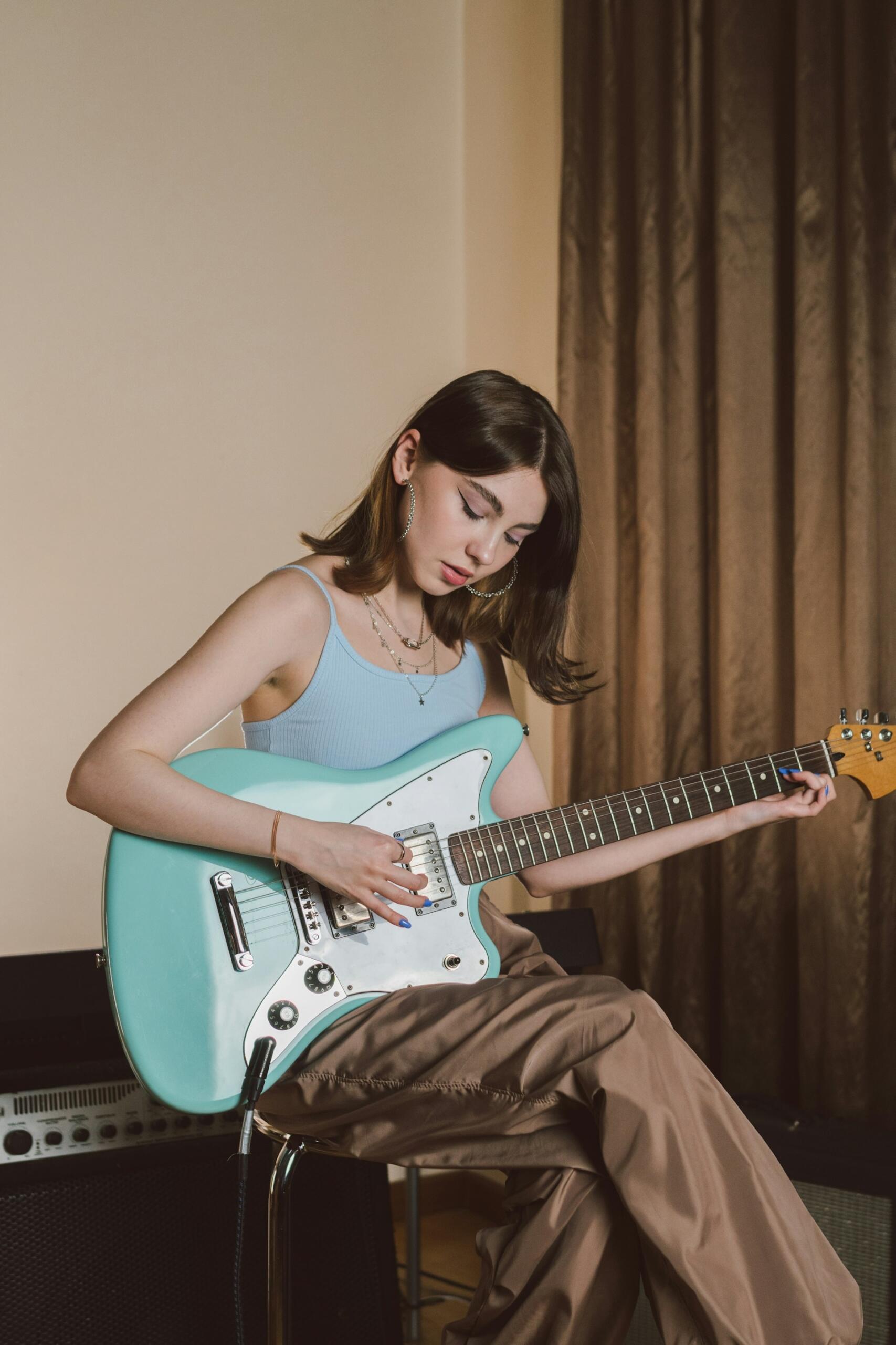 Ragazza si esercita per capire quanto tempo per imparare a suonare la chitarra,