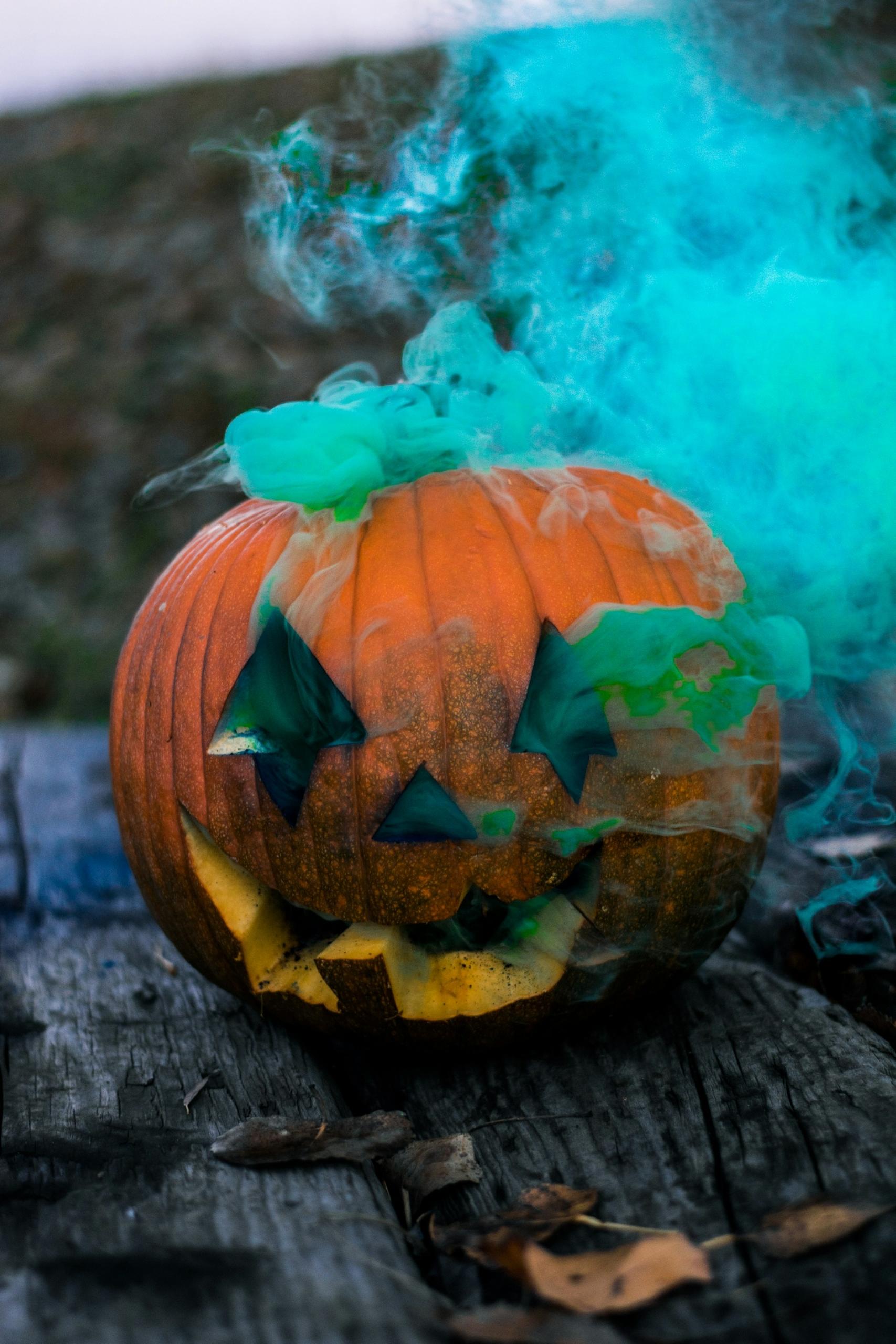 Zucca di halloween da cui esce un fumo azzurro.