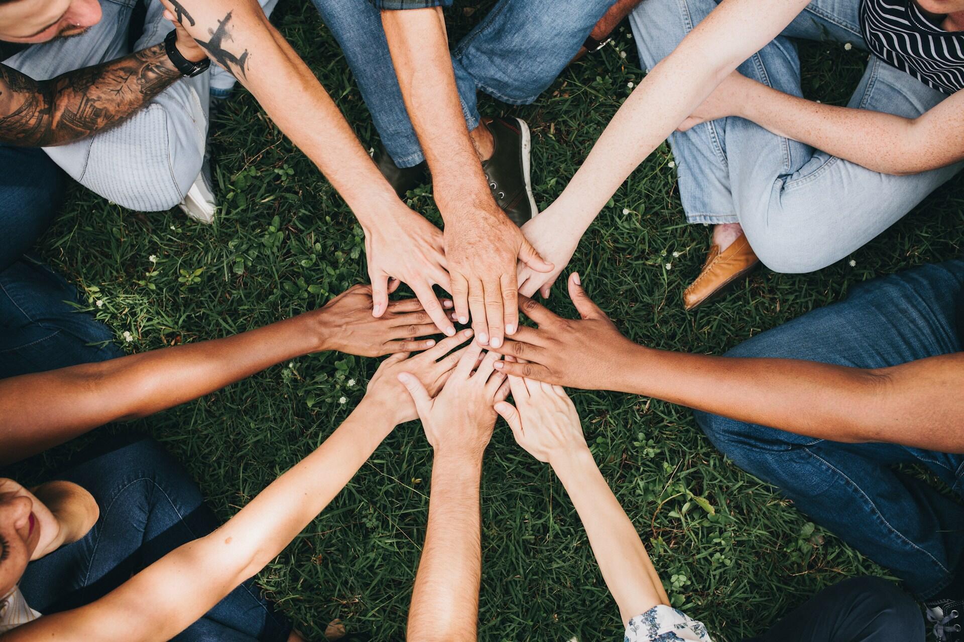 Giovani uniscono le mani in segno di collaborazione.