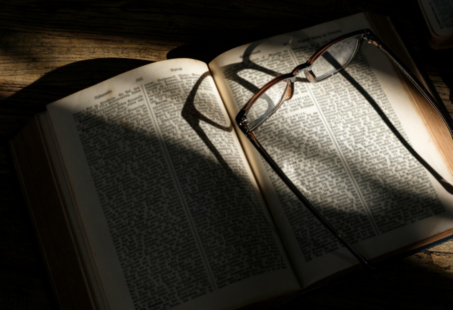 Occhiali su un dizionario in cui cercare frasi in tedesco.