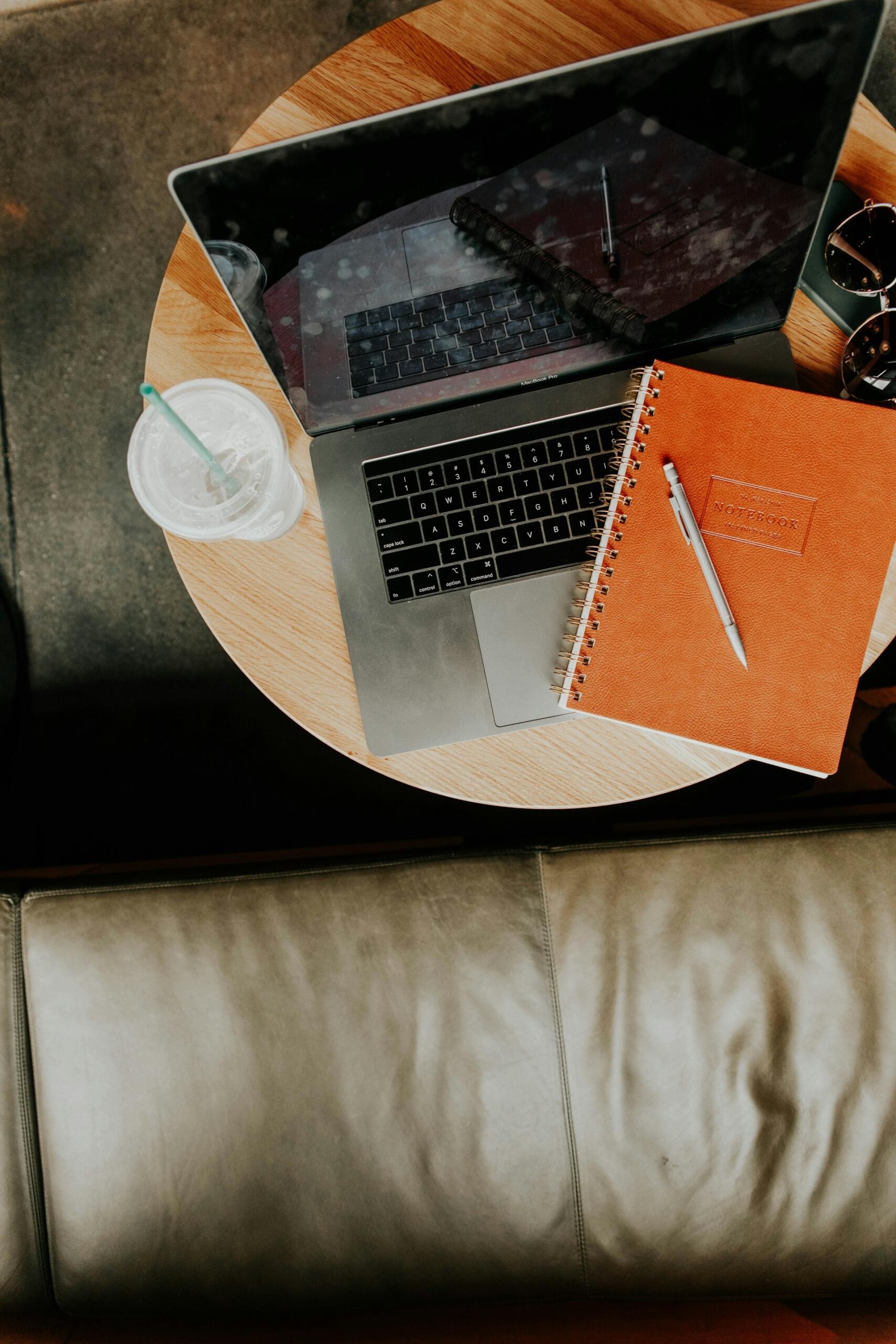 computer e quaderno appoggiati su un tavolino