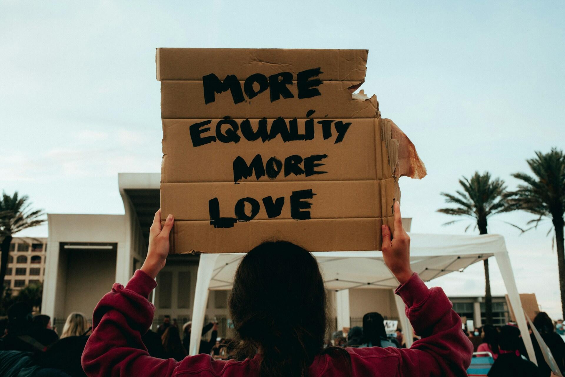 Cartellome "More equality, more love", slogan centrale nella storia del femminismo.