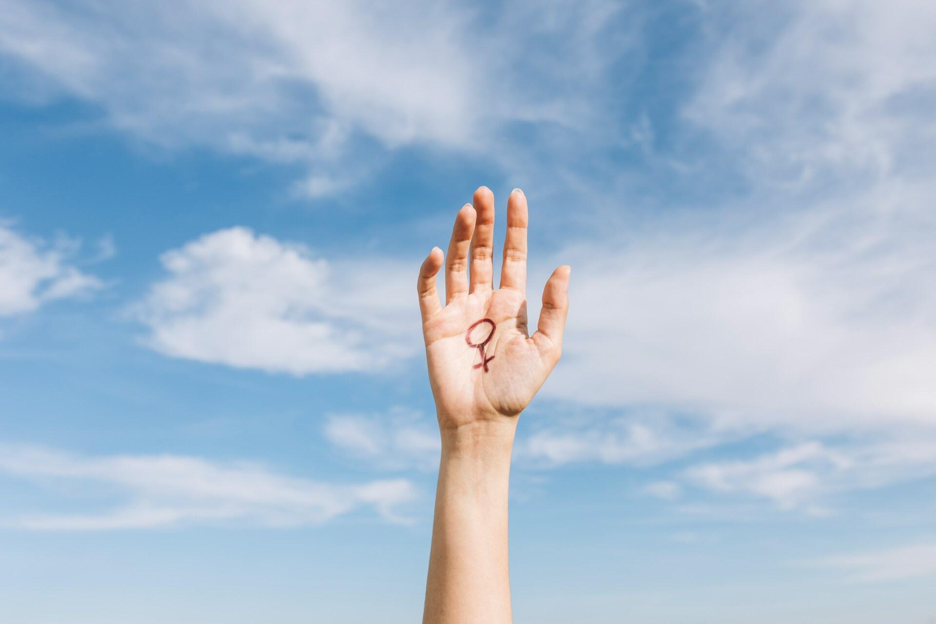 Mano con il simbolo del femminile, che simboleggia cosa significa essere femminista