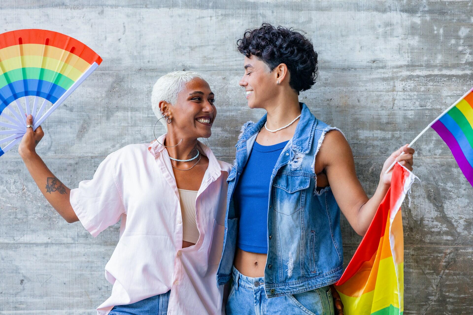 Attiviste con bandiere arcobaleno: il femminismo è per tutti.