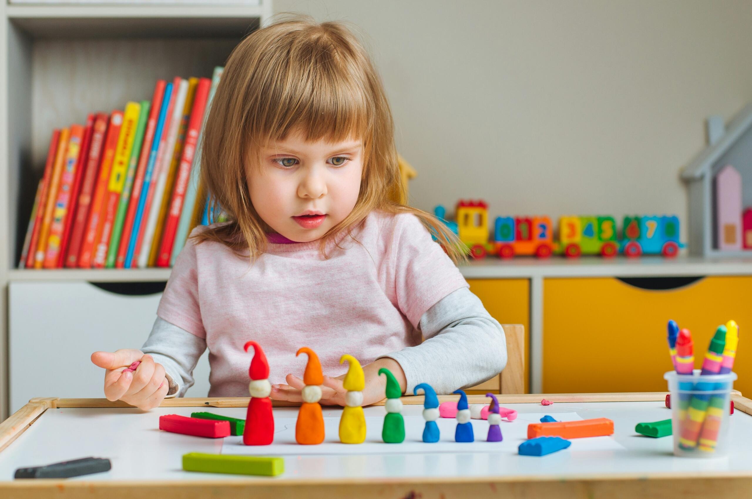 Bambina gioca con il pongo.
