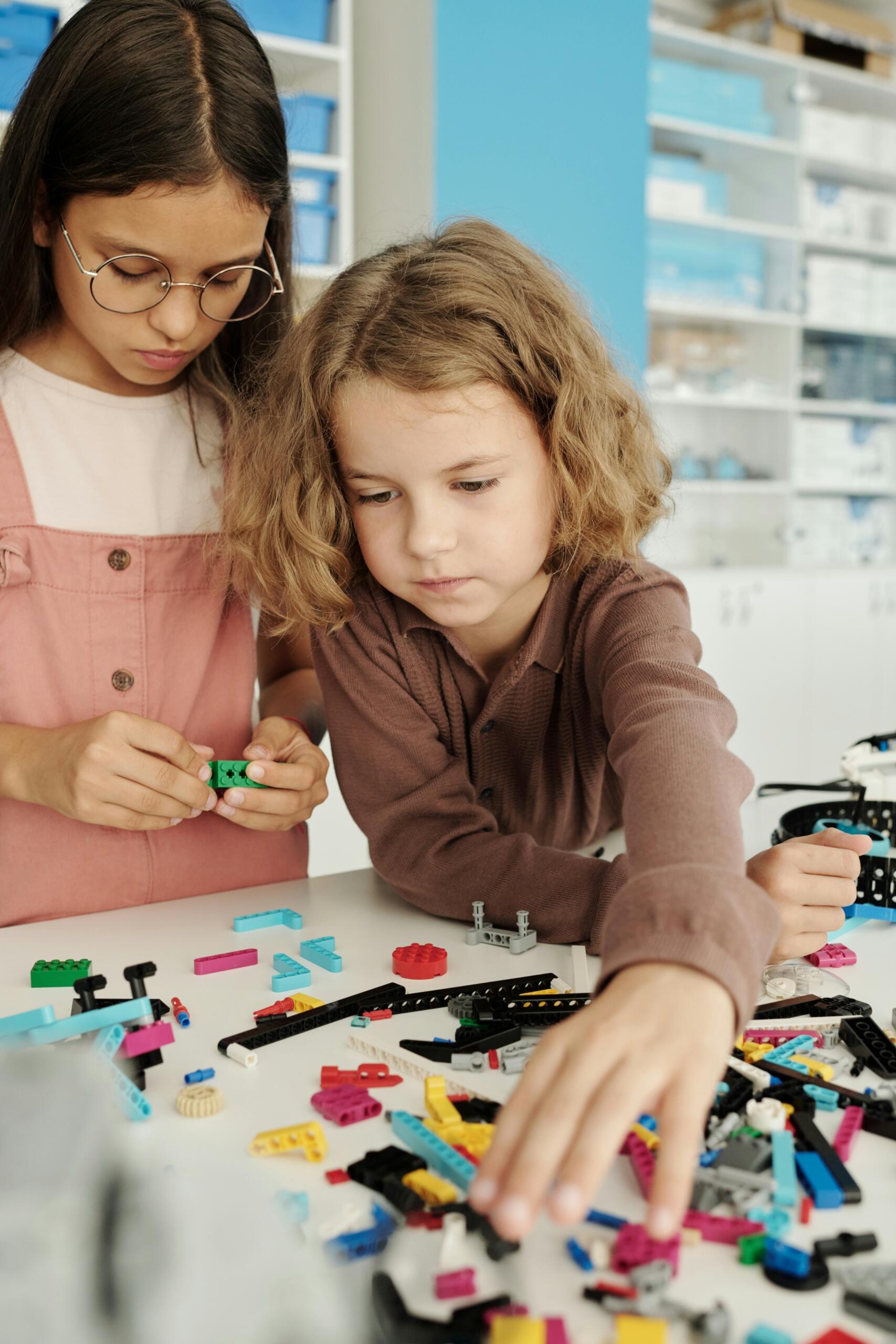 Due bambini giocano in classe con i lego.