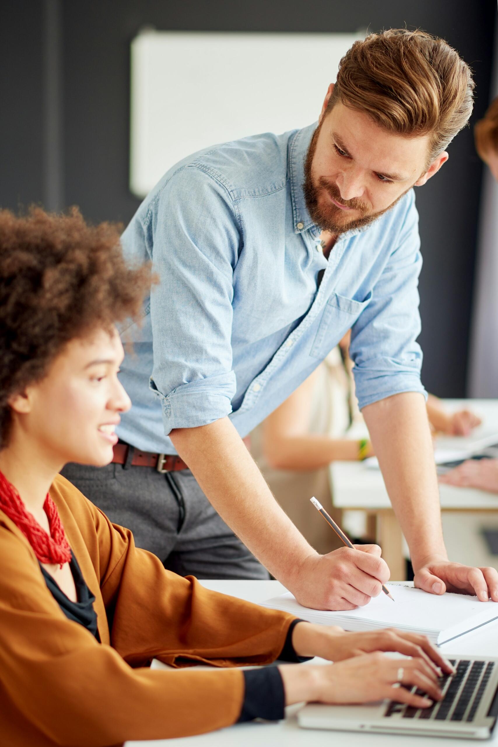 Una studentessa tenta una simulazione di un esame di maturità guidata da un'insegnante. 