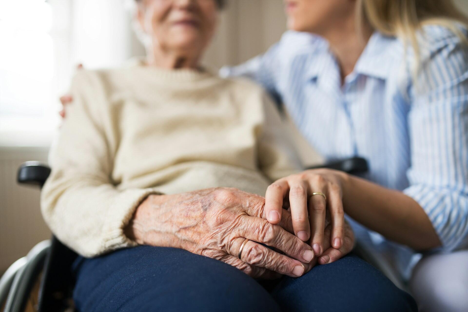 Donna accudisce un'anziana, uno dei motivi per ottenere la pensione insegnanti anticipata.