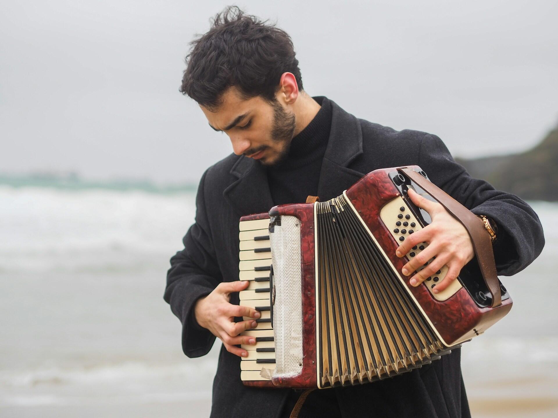 Un musicista italiano suona la fisarmonica in spiaggia.