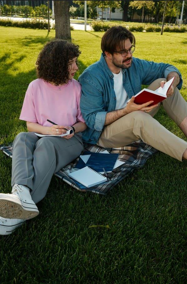 due ragazzi studiano al parco seduti per terra