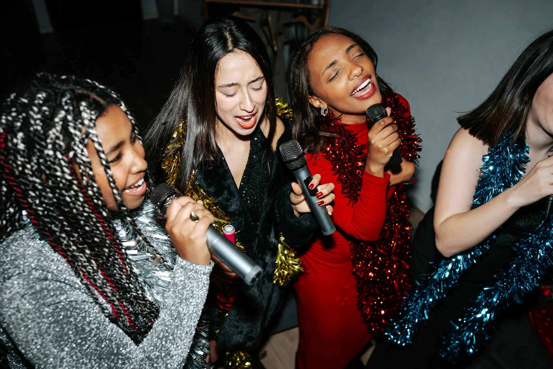 Ragazze cantano divertendosi al karaoke.