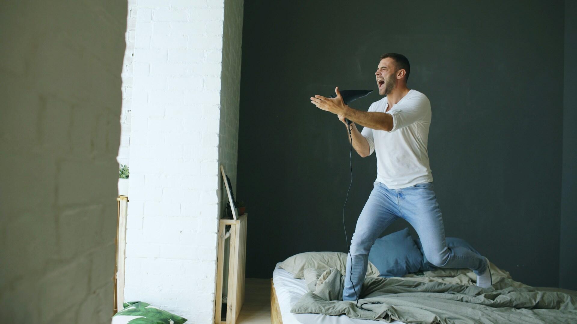 Un uomo canta usando un phon come microfono.