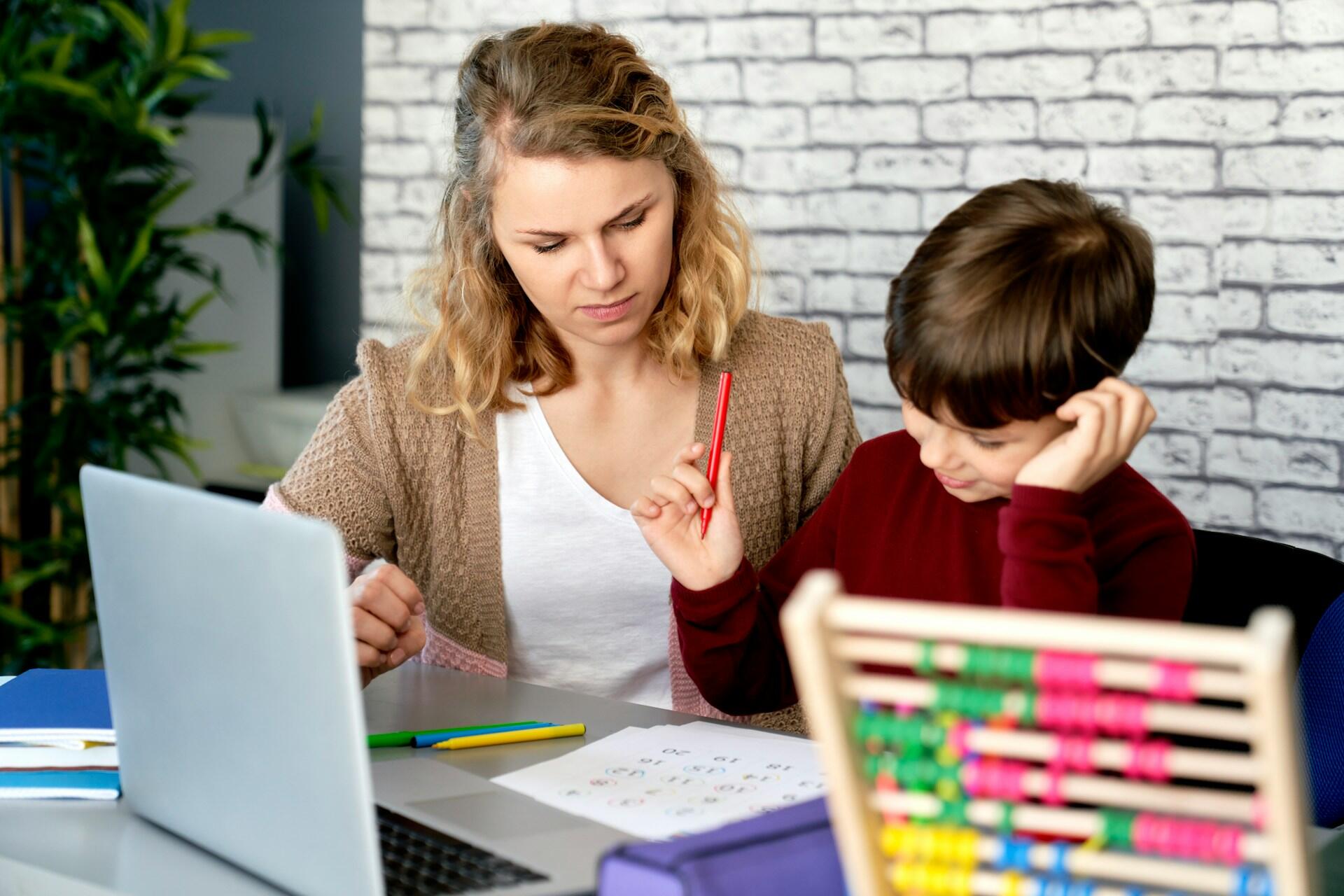 Insegnante di matematica aiuta bambino a svolgere i compiti.