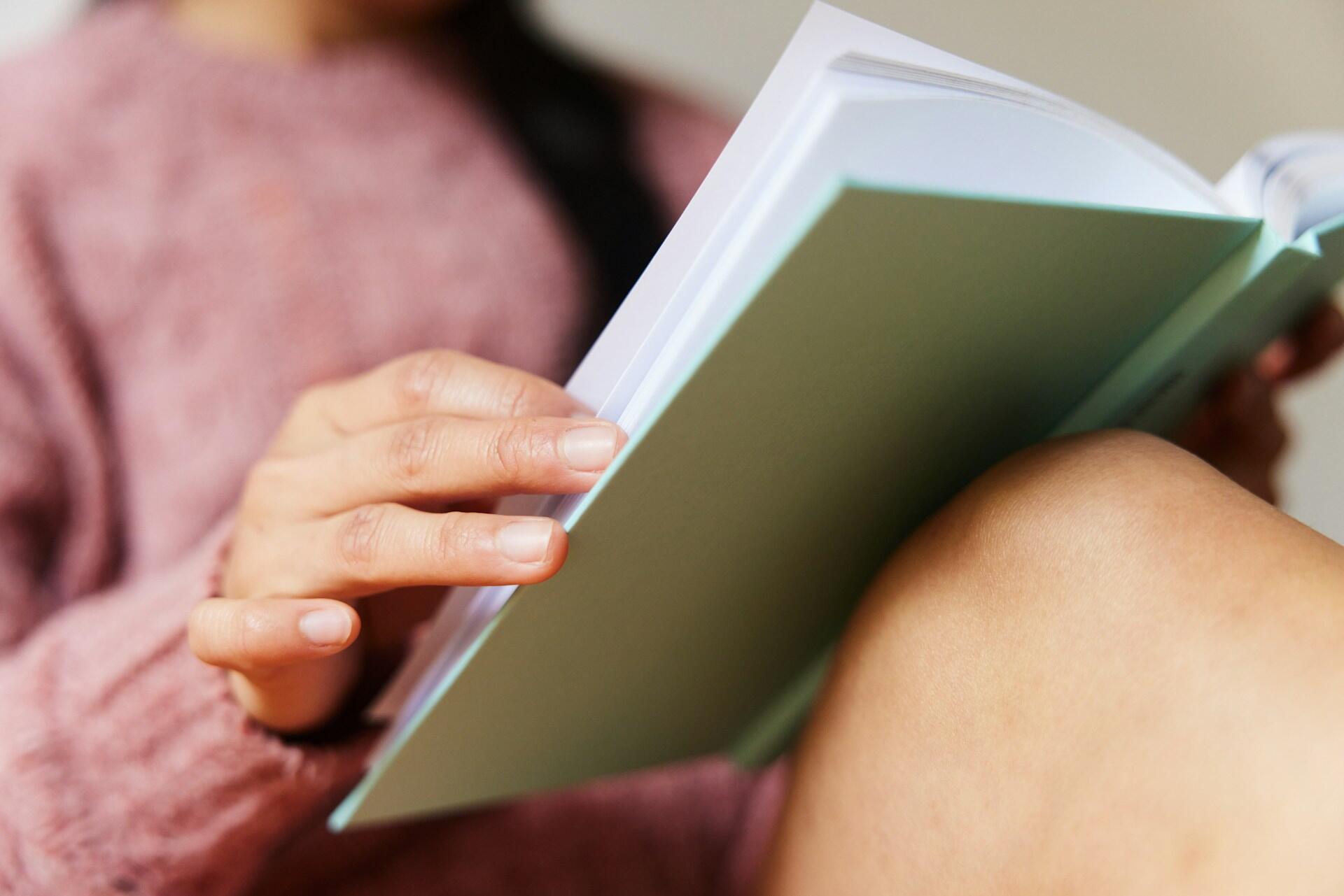 Ragazza studia l'alfabeto spagnolo su un libro.