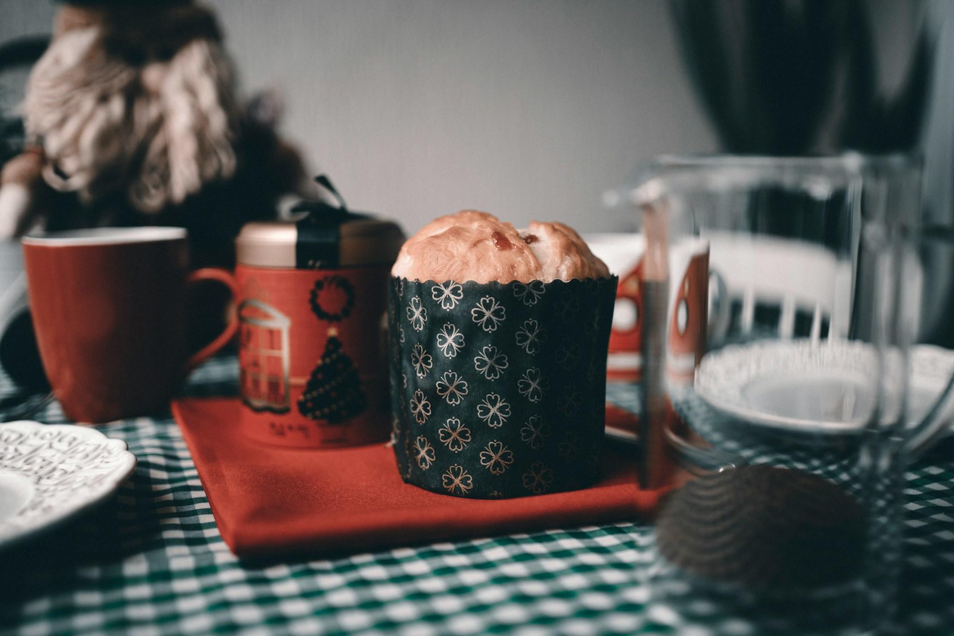 Tavola per le Feste di Natale con tazze rosse e panettone