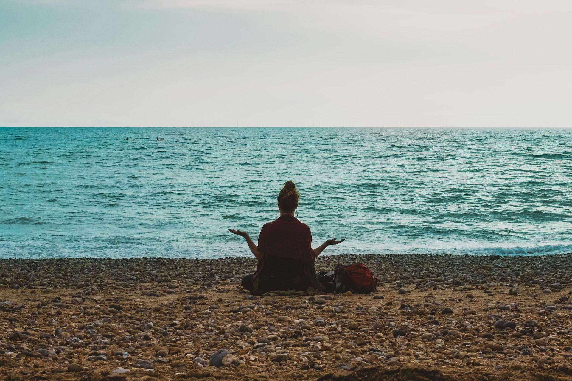 Ragazza che medita di fronte al mare