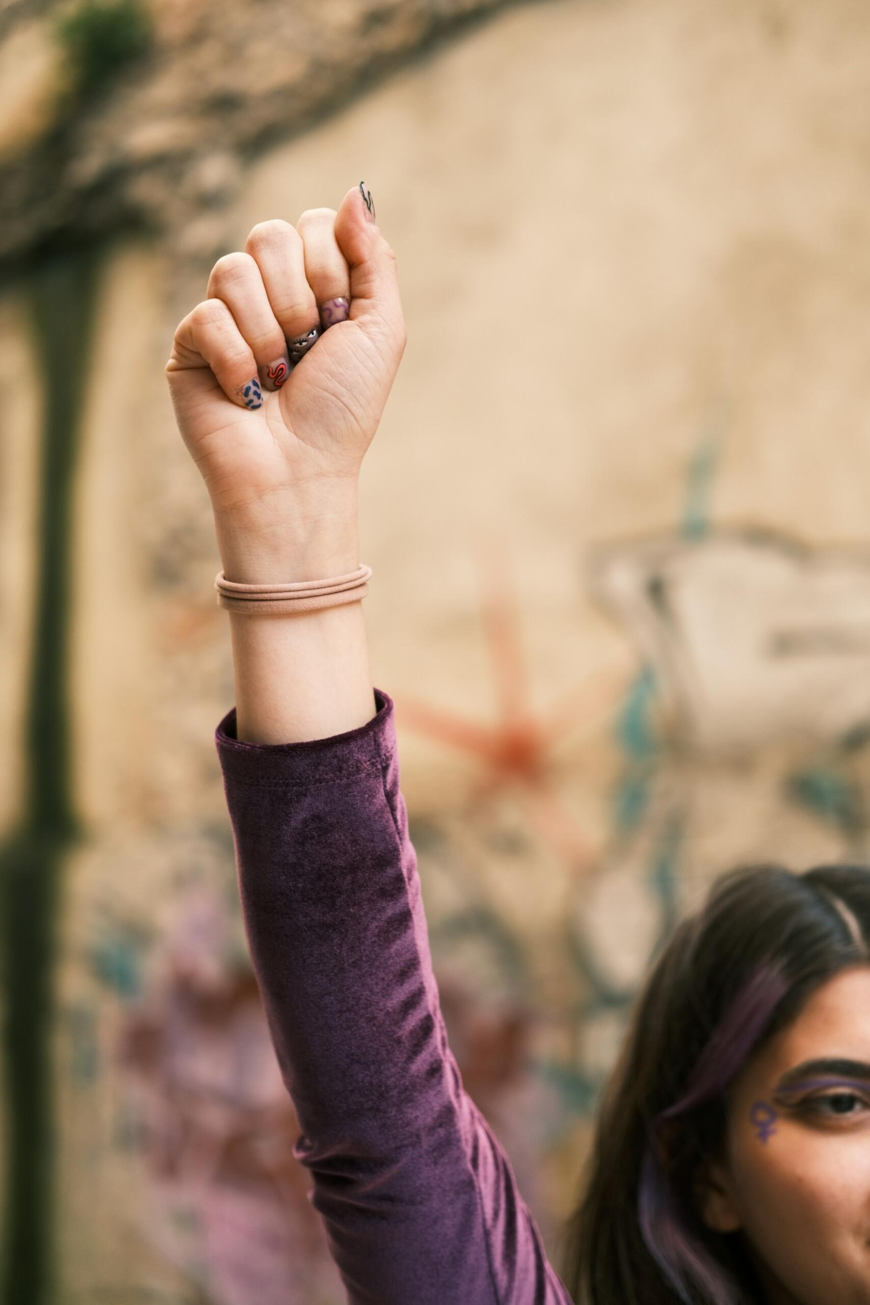 Pugno chiuso di una ragazza per celebrare le donne che hanno fatto la storia.