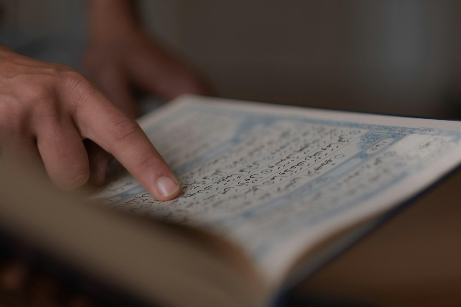 Studente legge un testo scritto con l'alfabeto arabo.