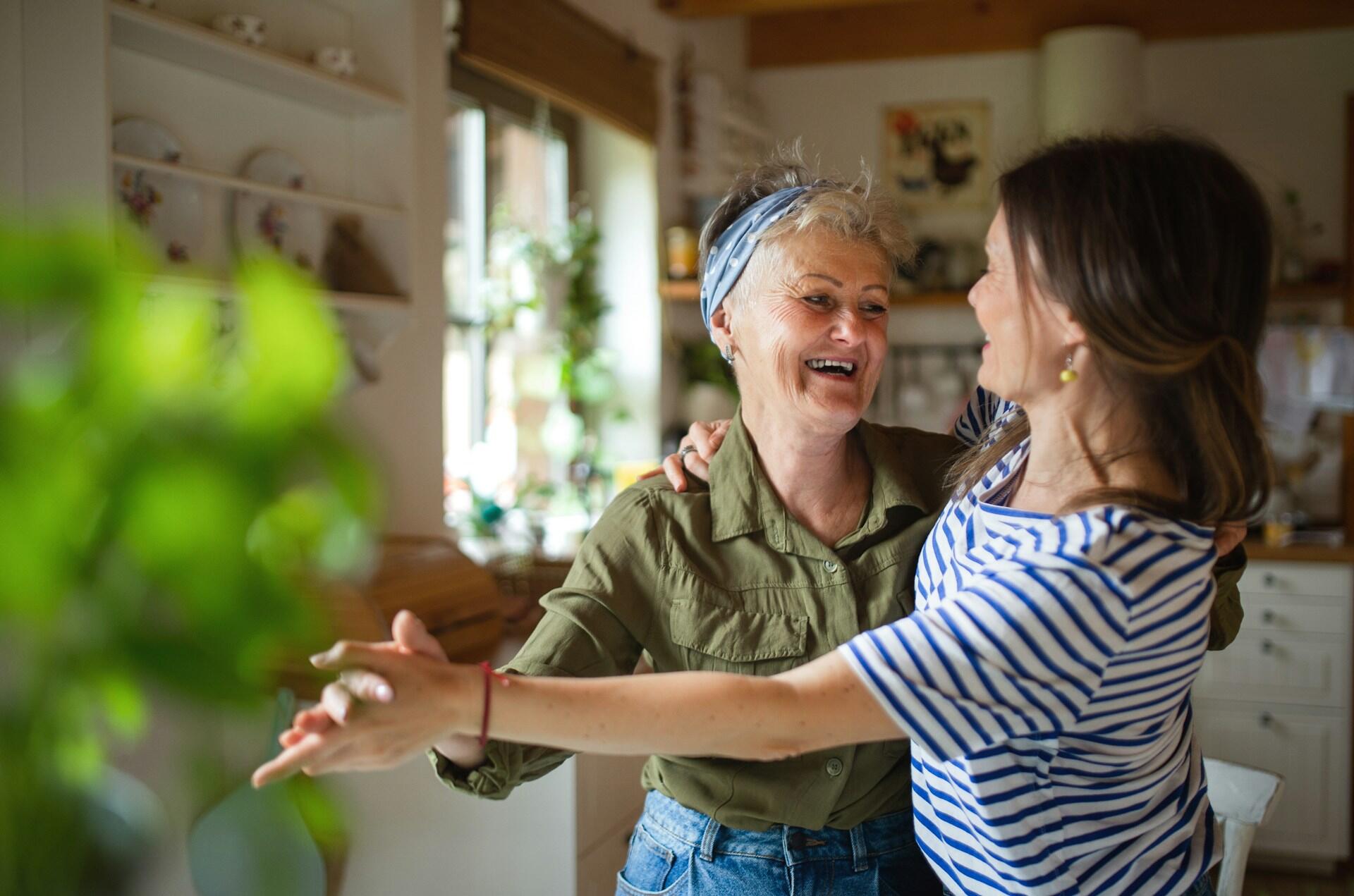 Madre e figlia ballano in una cucina.
