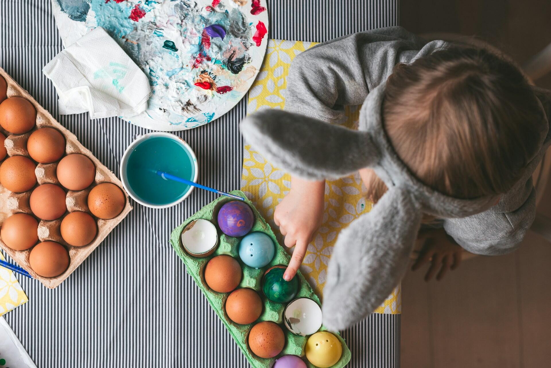 Bambino decora le uova, una delle tradizioni pasquali più note.