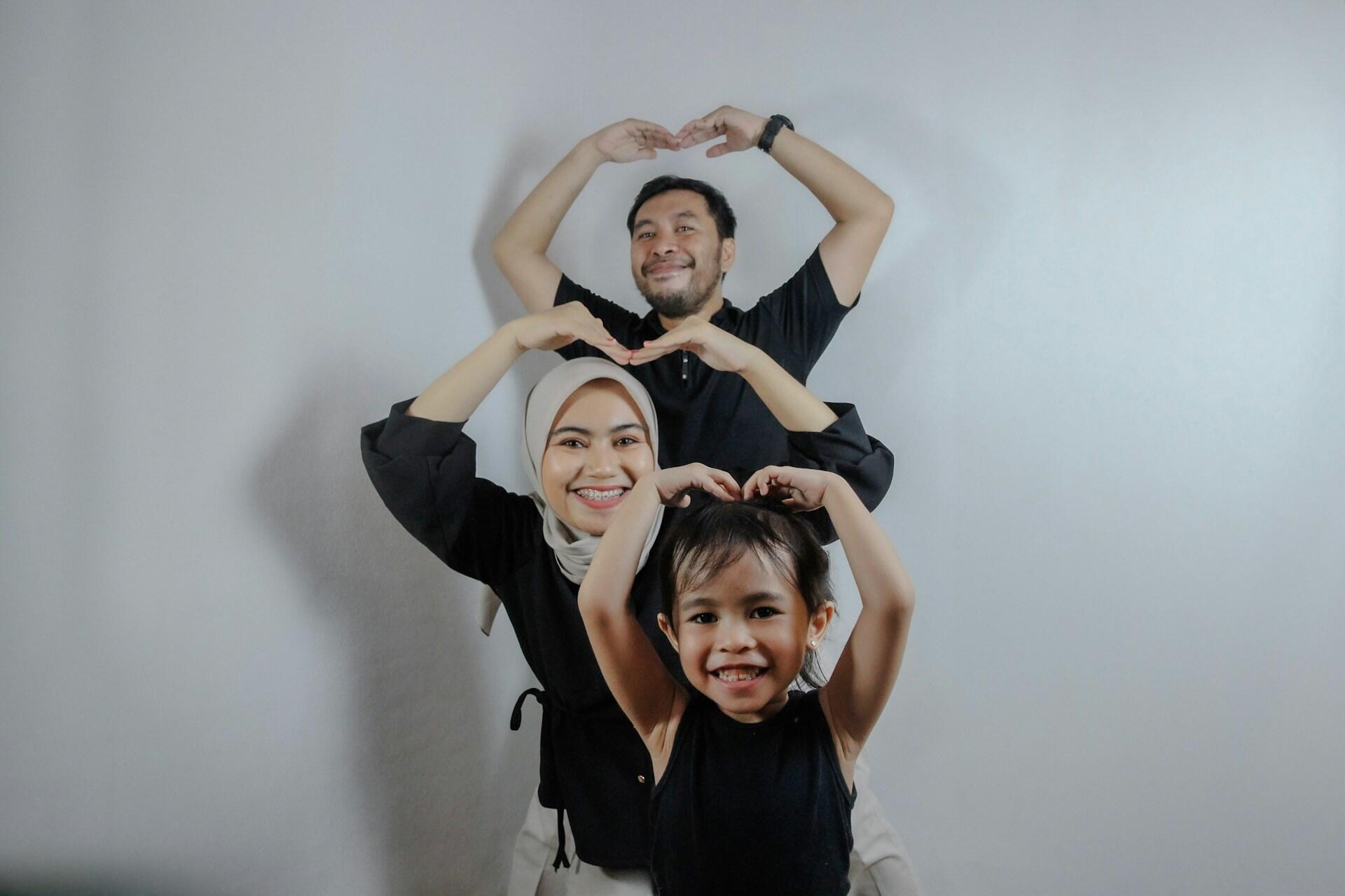 famiglia che si fotografa facendo simbolo del cuore con le braccia
