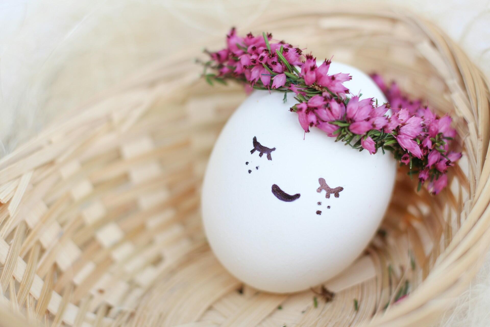 uovo con occhi disegnati e coroncina di fiori
