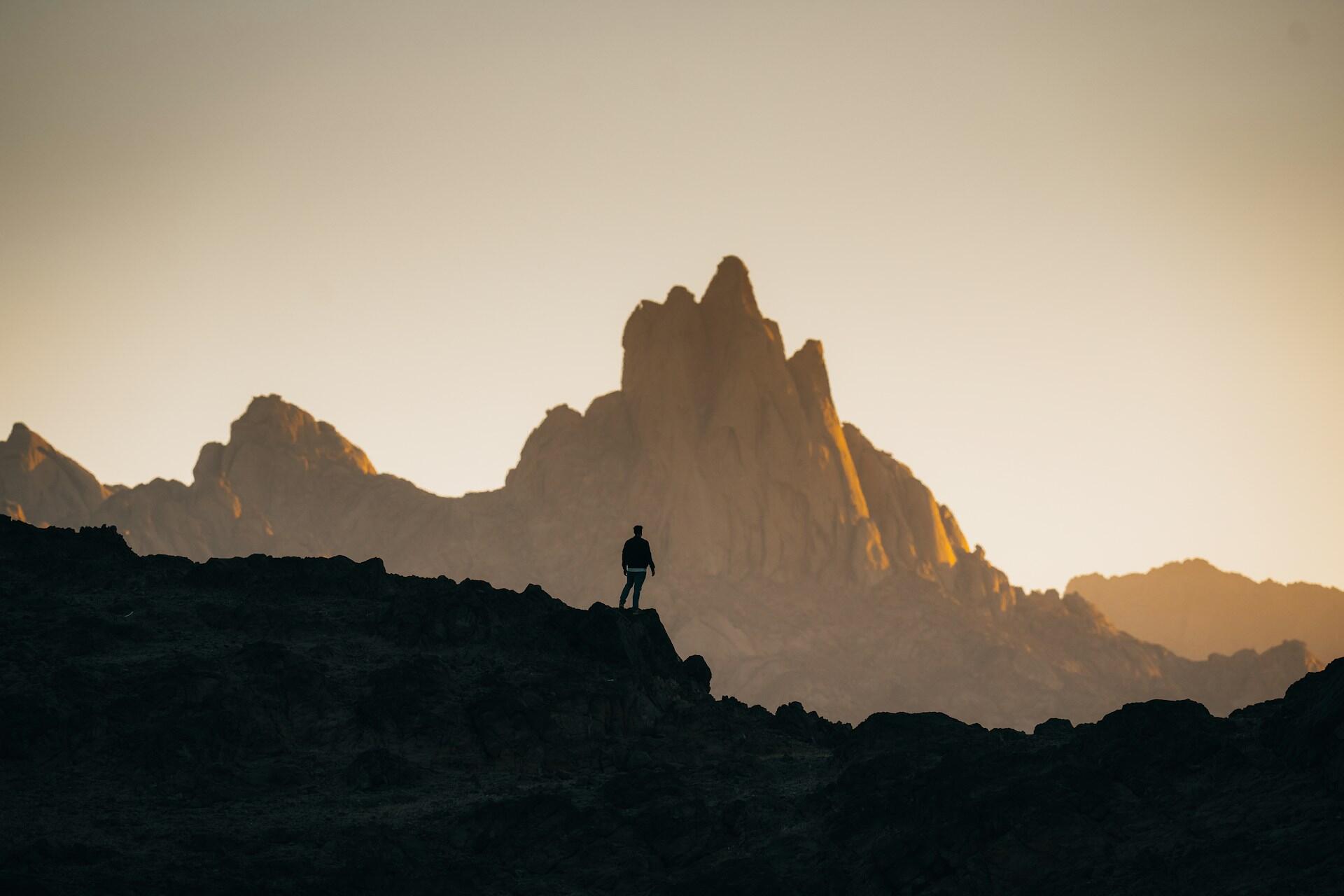 Un ragazzo osserva una montagna sognando di scalarla.