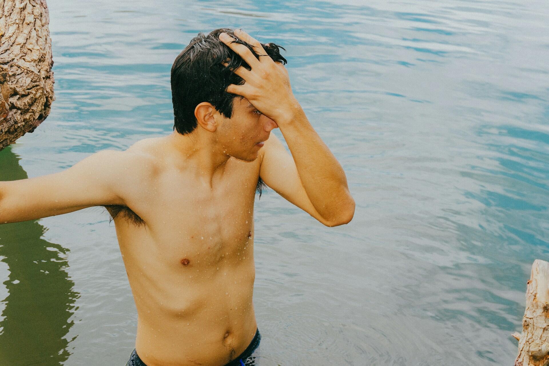 Ragazzo fa il bagno in un fiume.