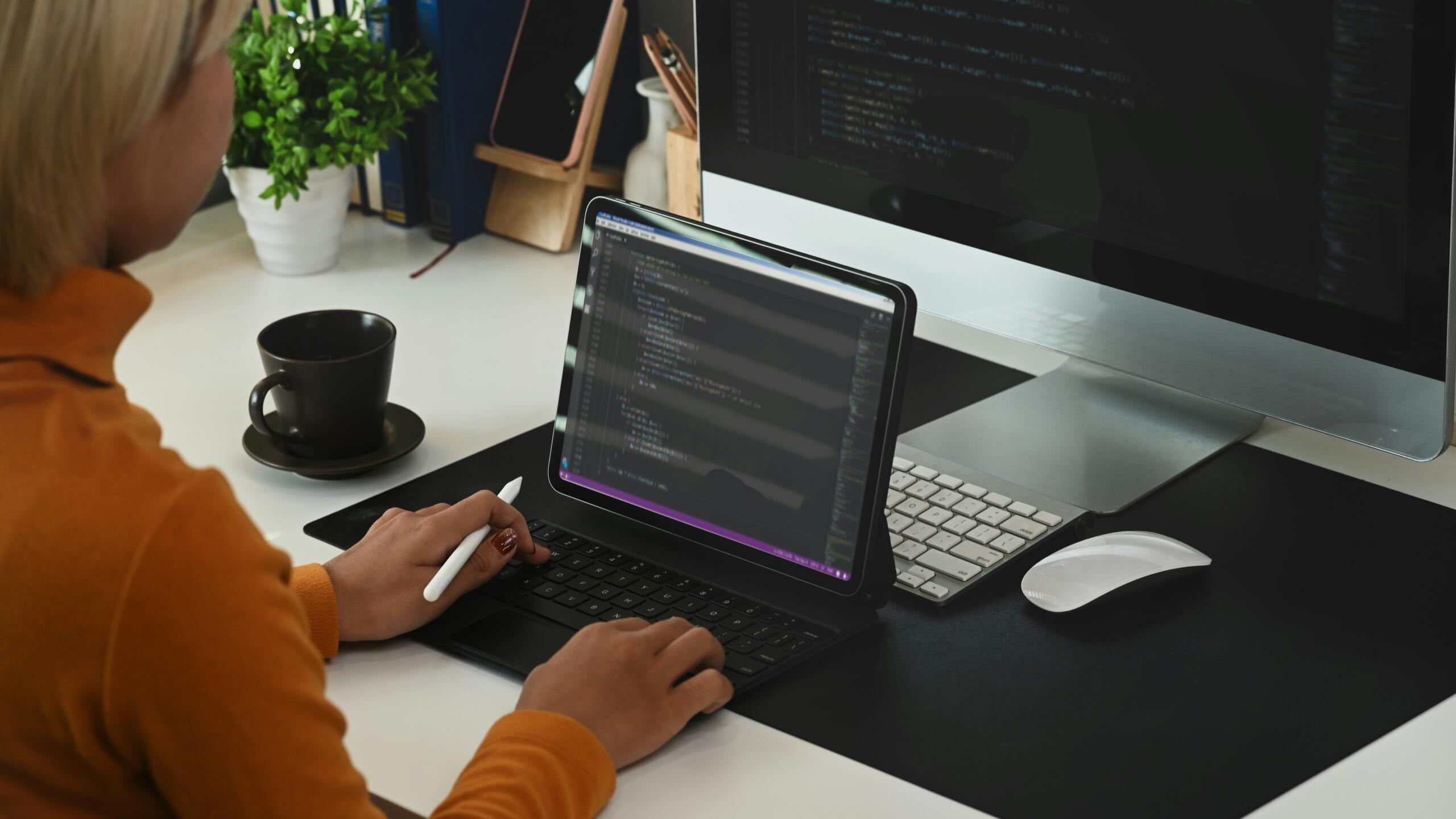 Donna scrive codice sul programma di coding al pc.