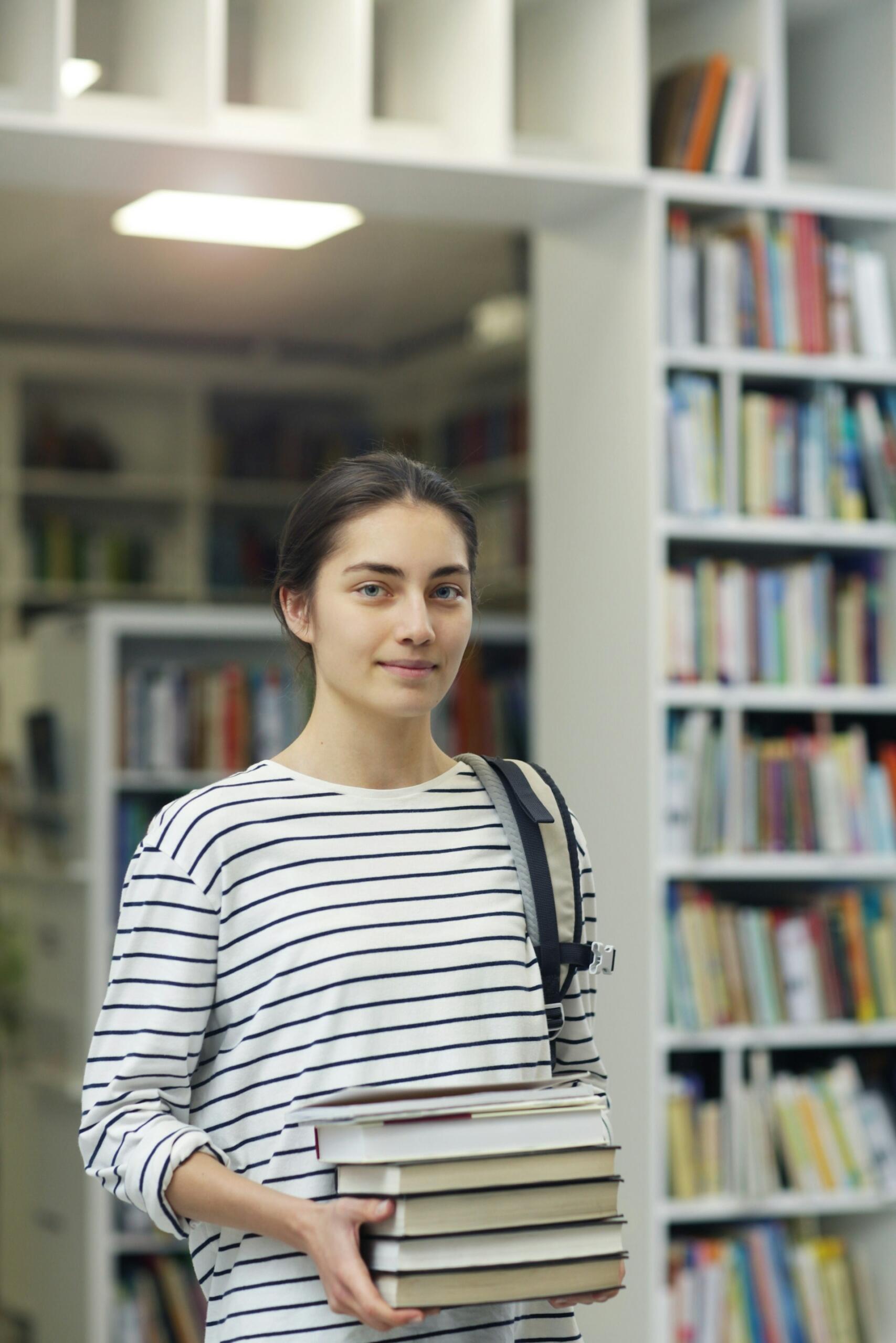 Ragazza in biblioteca studia per affrontare il debito formativo superiori.