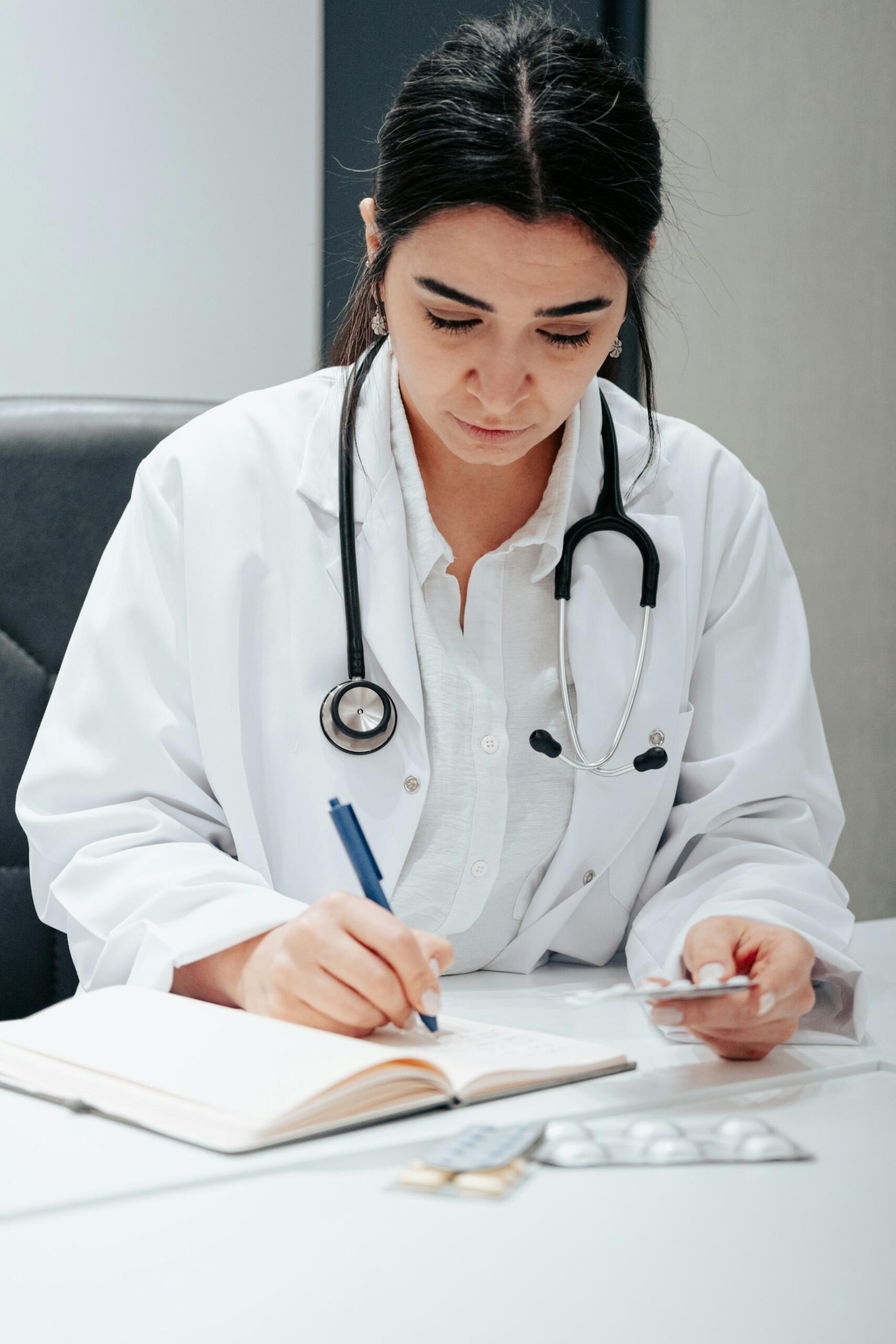Una dottoressa annota informazioni riguardo ai farmaci di un paziente.
