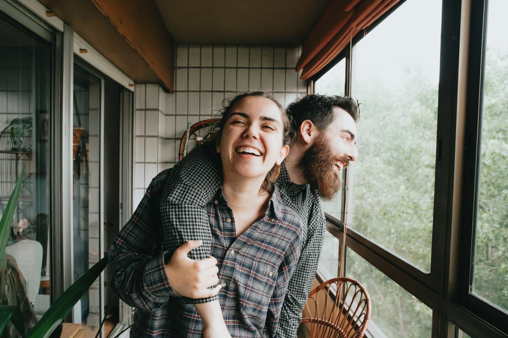Una coppia si abbraccia e sorride, comunicando serenità e spensieratezza.