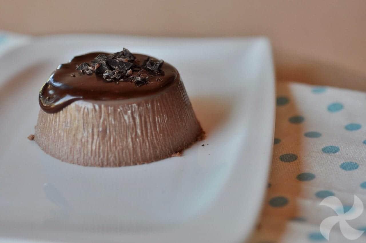Piatto bianca su cui è adagiata una panna cotta al cacao.