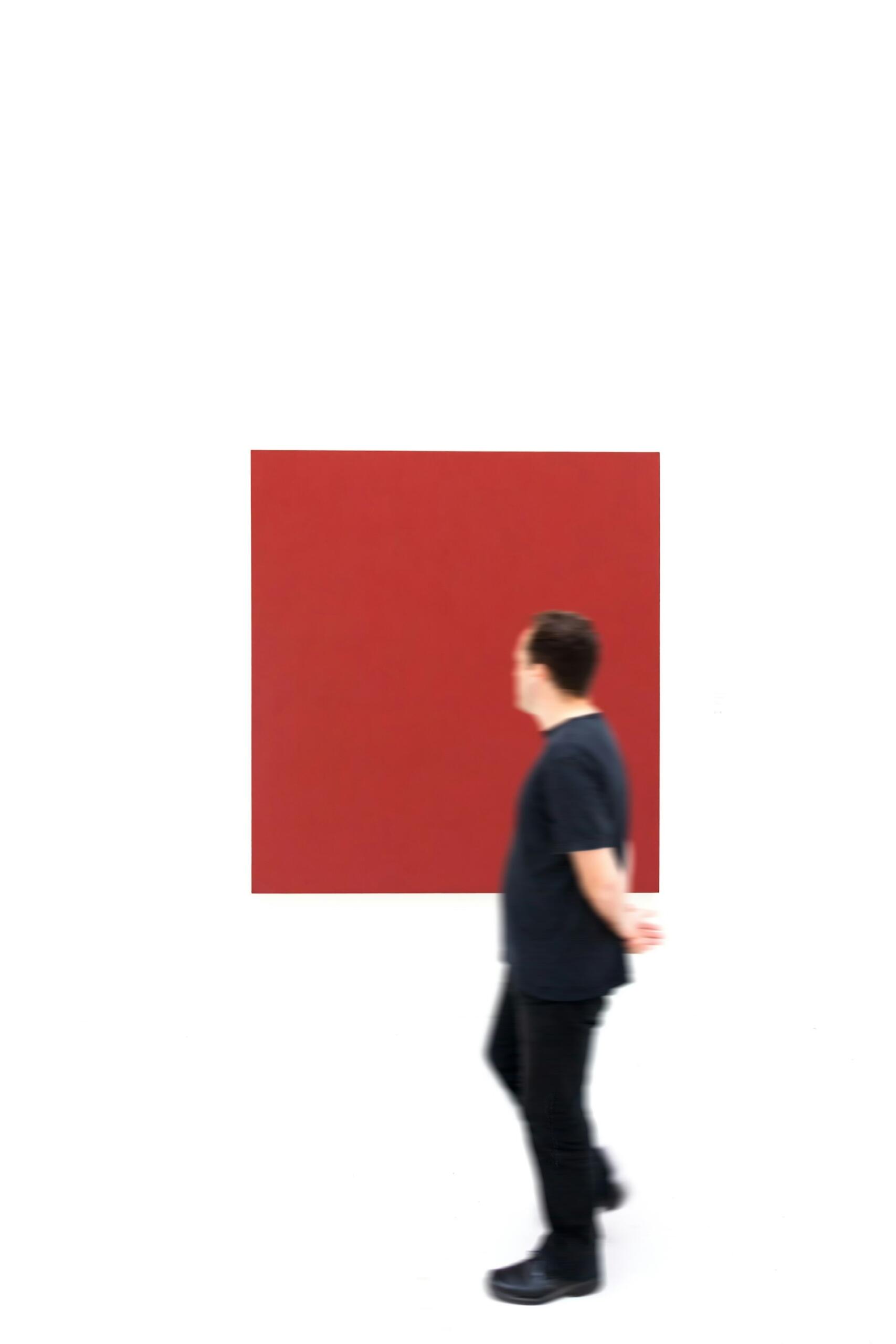 Un fruitore passeggia in una galleria d'arte contemporanea. 