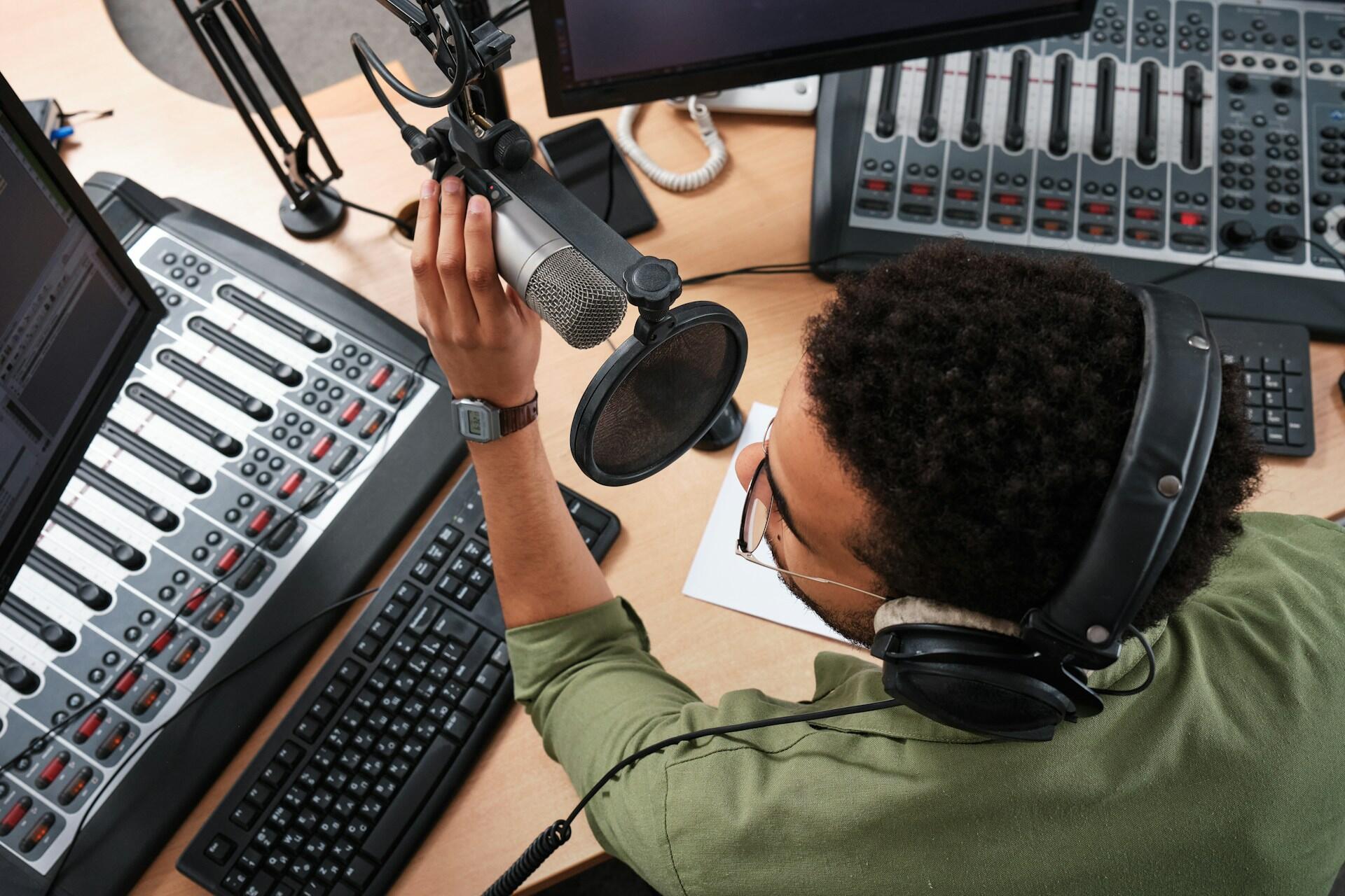 Un ragazzo parla al microfono durante una trasmissione radiofonica. 