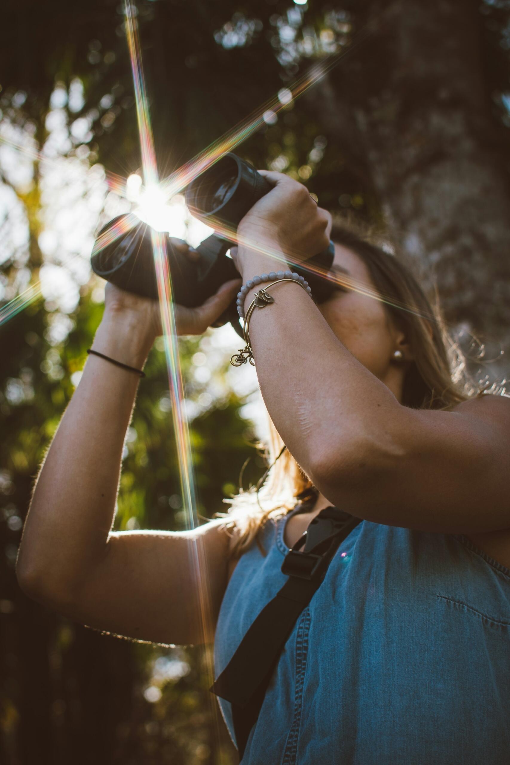 Una donna osserva la fauna locale con un binocolo. 