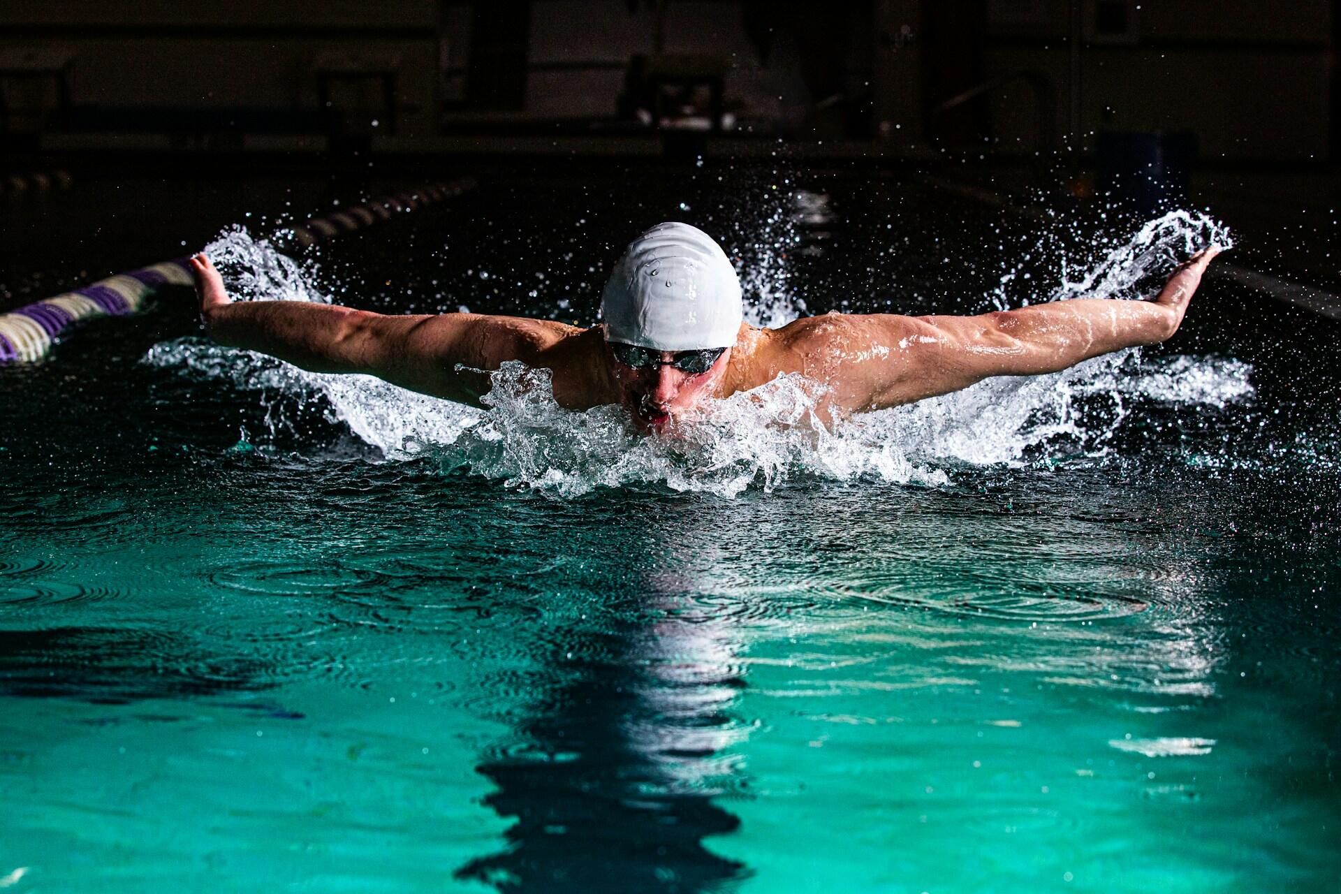 Un ragazzo nuota in una piscina. 