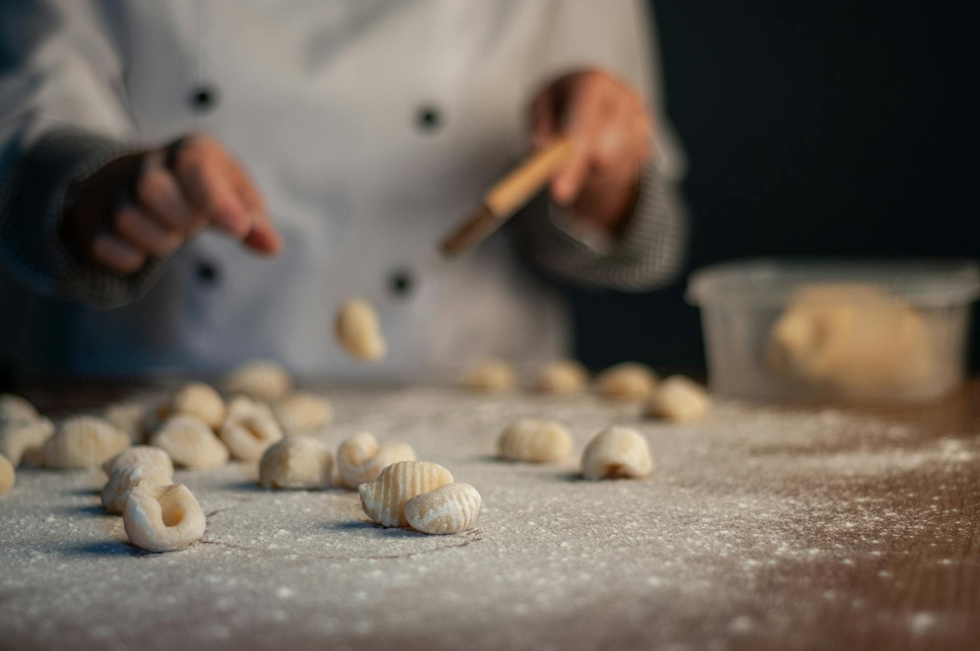 Uno chef sta preparando una grande quantità di gnocchi. 