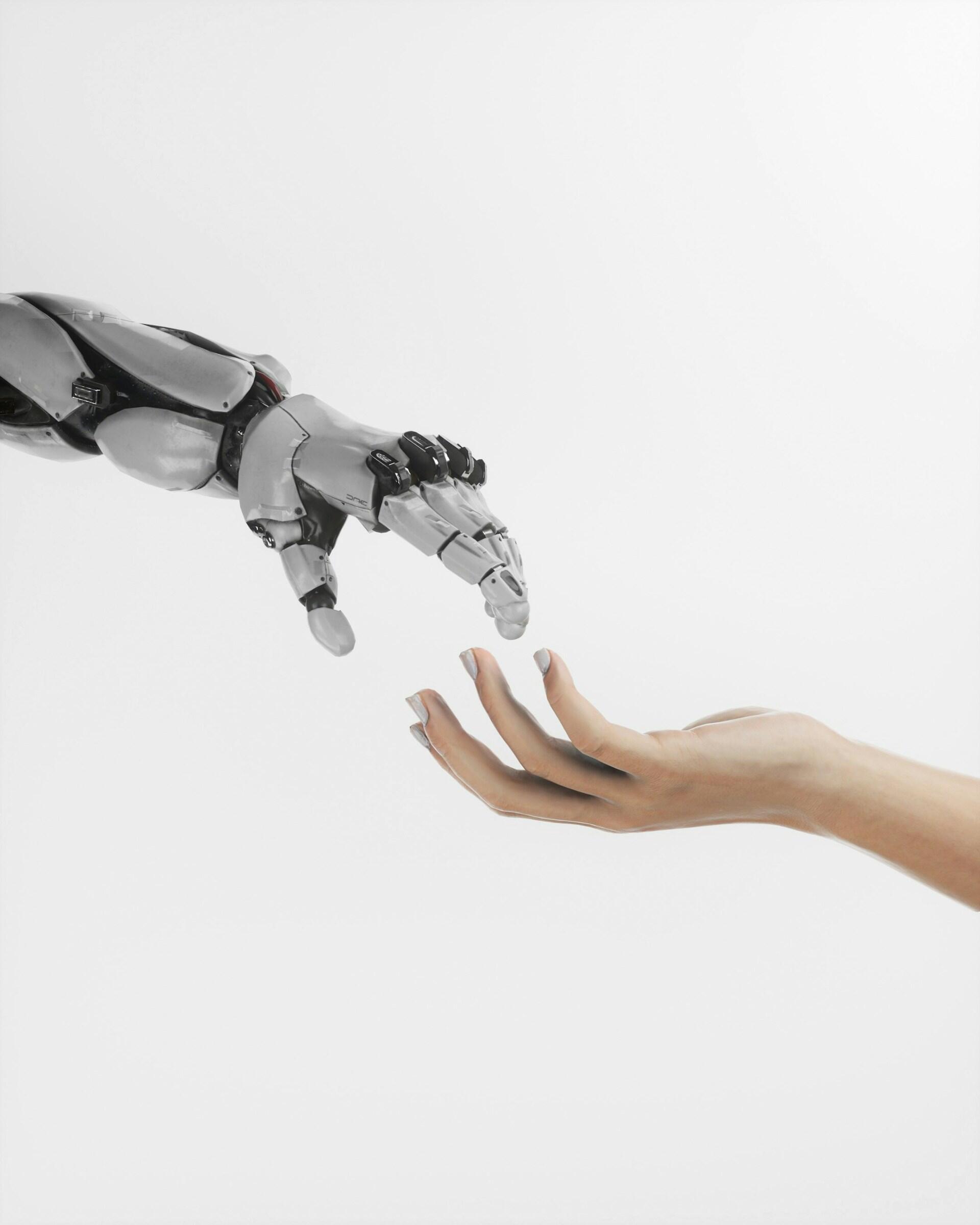 Una mano robotica e una mano umana tendono una verso l'altra. 