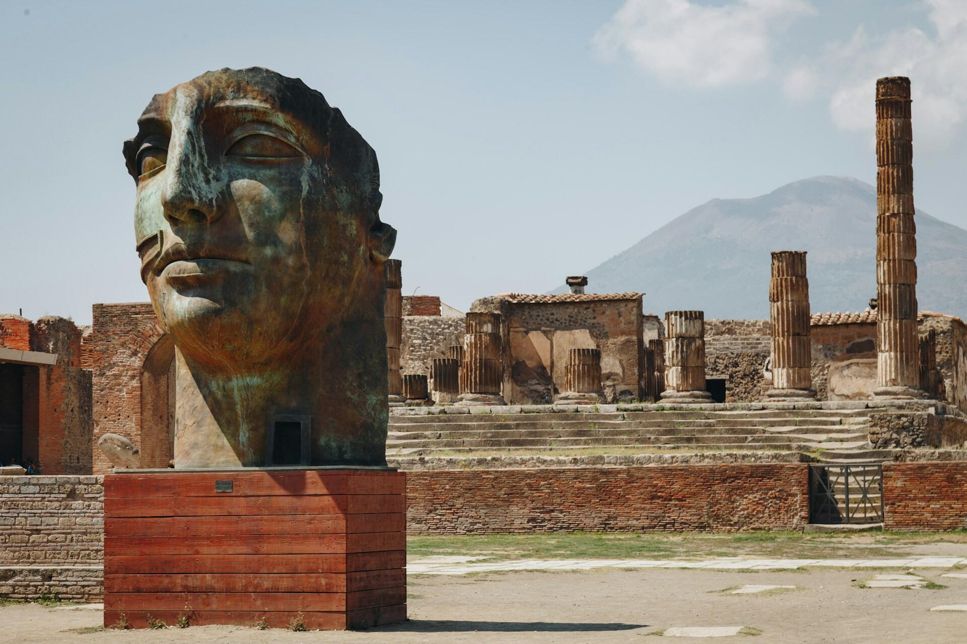 Statua di Pompei e il Vesuvio sullo sfondo.