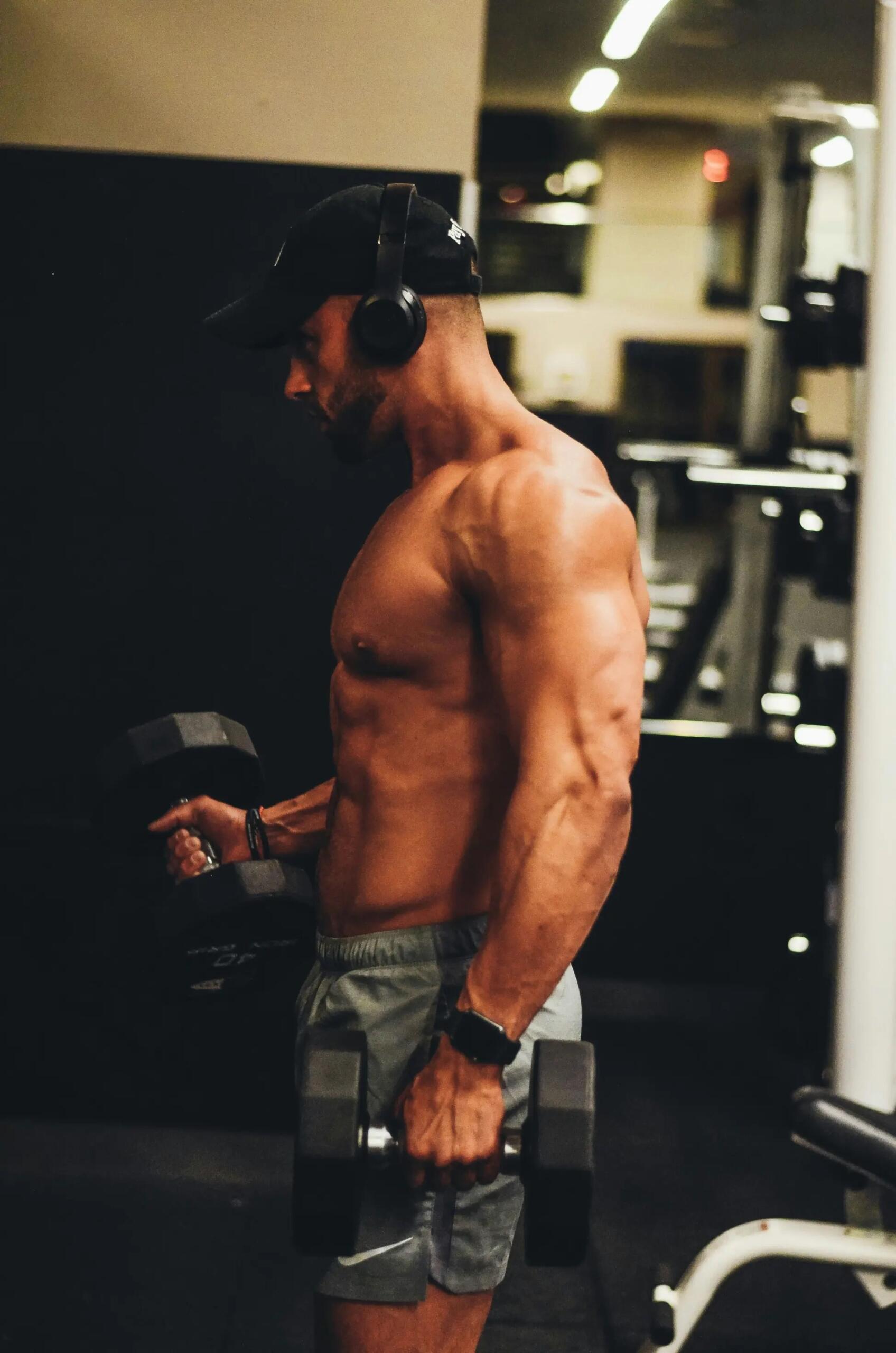 Un uomo si allena con manubri in palestra.
