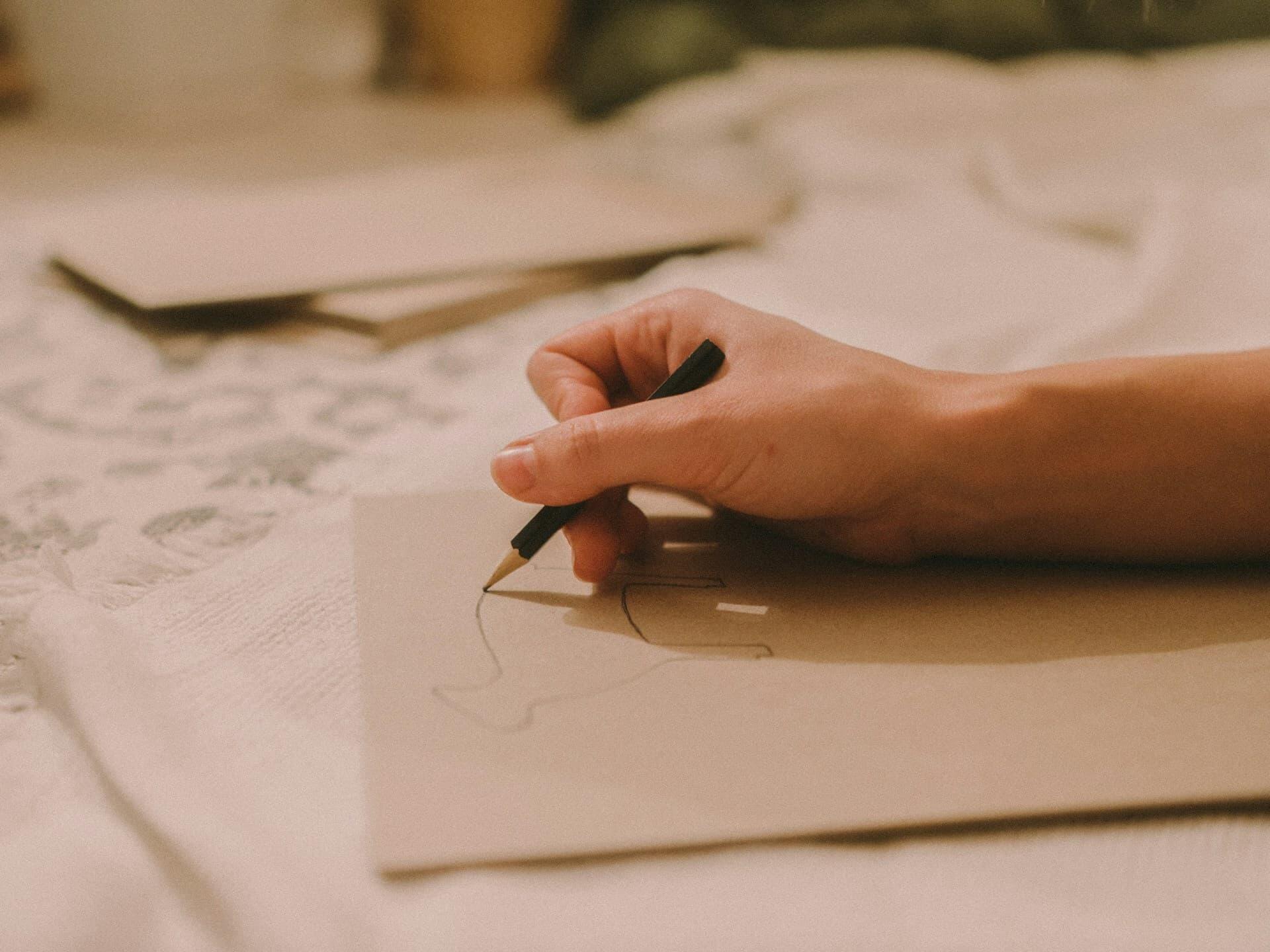 鉛筆で紙に絵の描き方を練習する手元