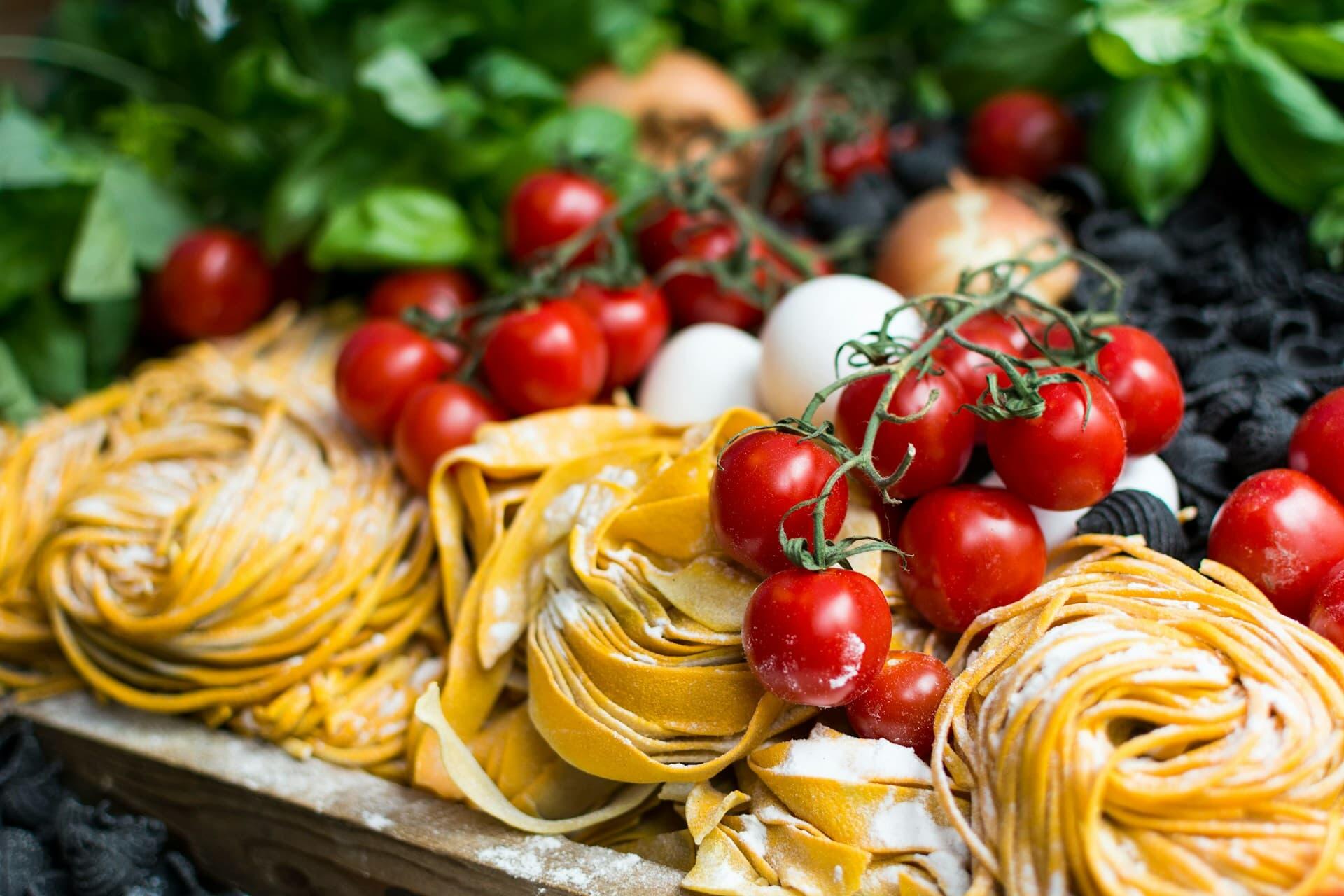 手打ちの生パスタとチェリートマトやバジルなどイタリアン郷土料理の食材