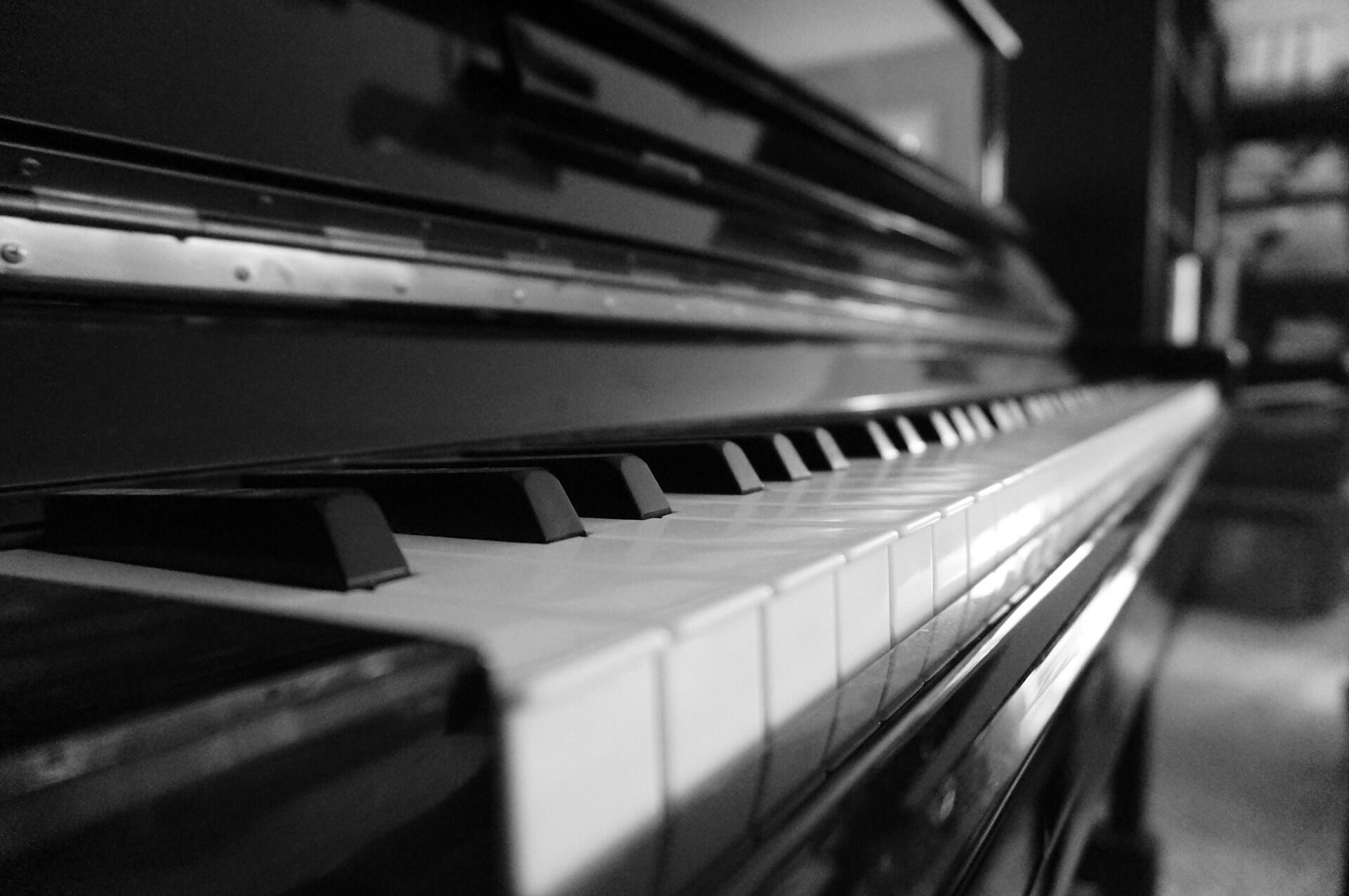 黒いアップライトピアノを横から見た写真