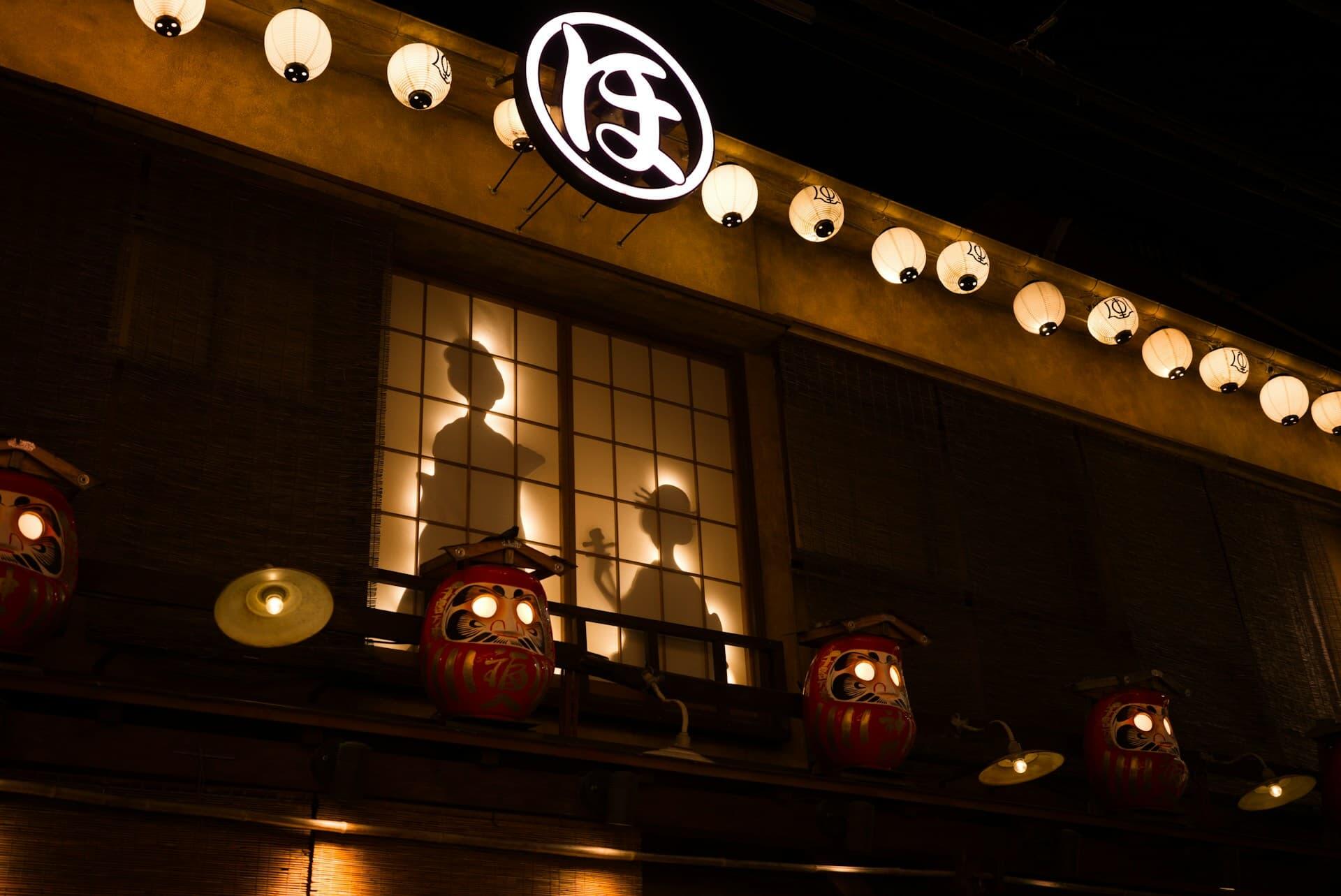 提灯とだるまが並ぶ日本の伝統的な祭りの夜景